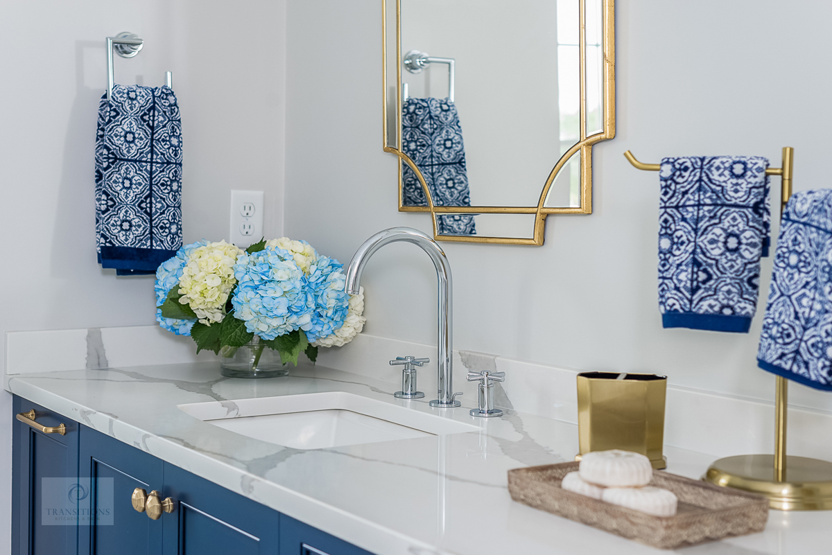 Vibrant blue Tedd Wood vanity with brass Atlas hardware and gold mirror in Cohasset