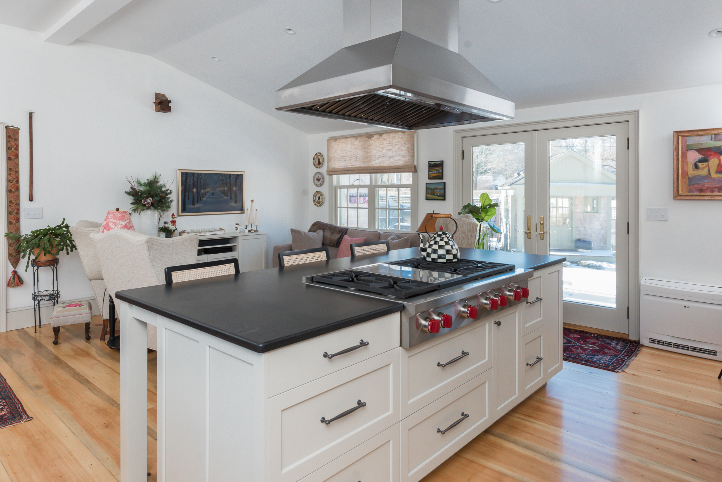 Kitchen island with cooktop and stainless hood in a Massachusetts home