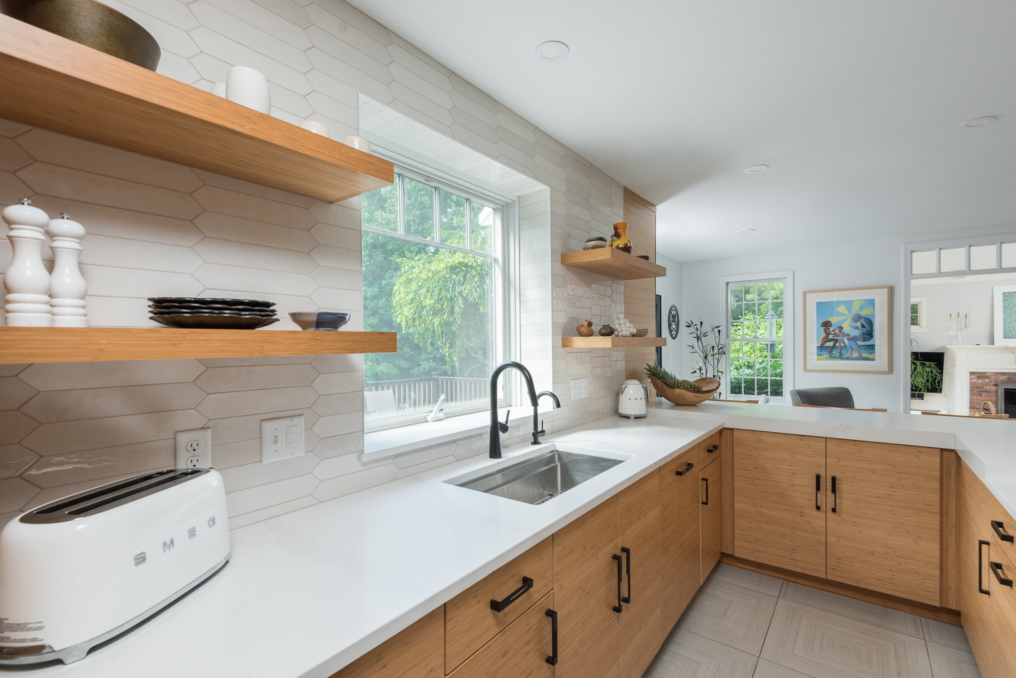 Frameless wood kitchen cabinets with stainless hood and tile backsplash in Hanover MA
