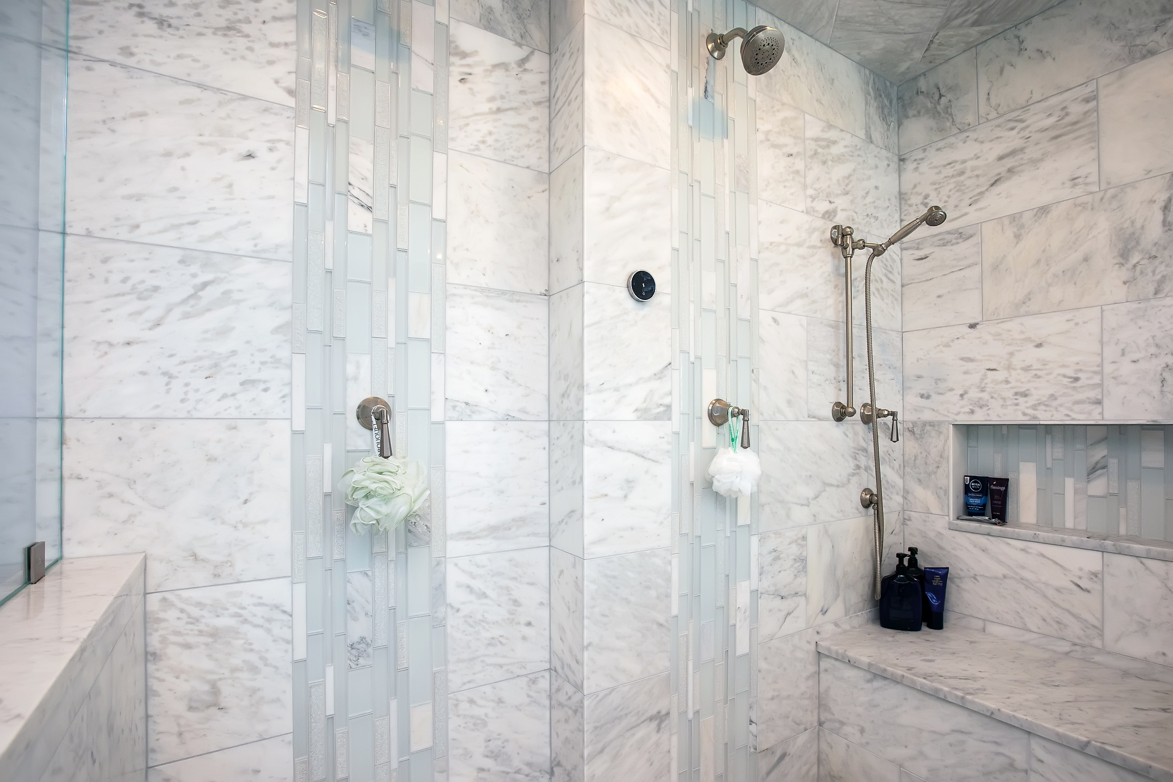Hingham primary bathroom with Carrara marble shower, glass mosaic accent strips, and built-in marble bench