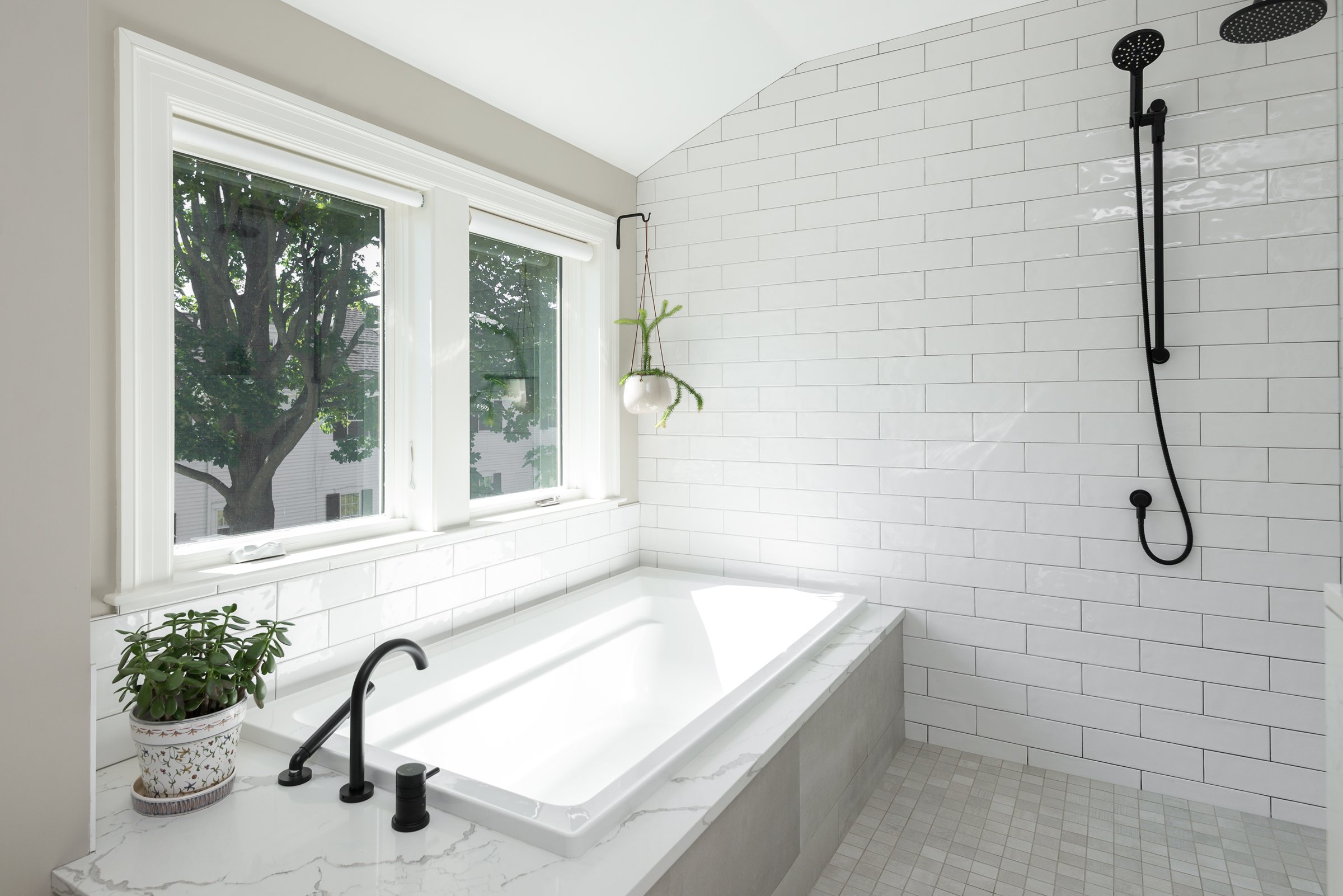 Hingham primary bathroom looking toward the doorway with white oak vanity and quartz tub deck.