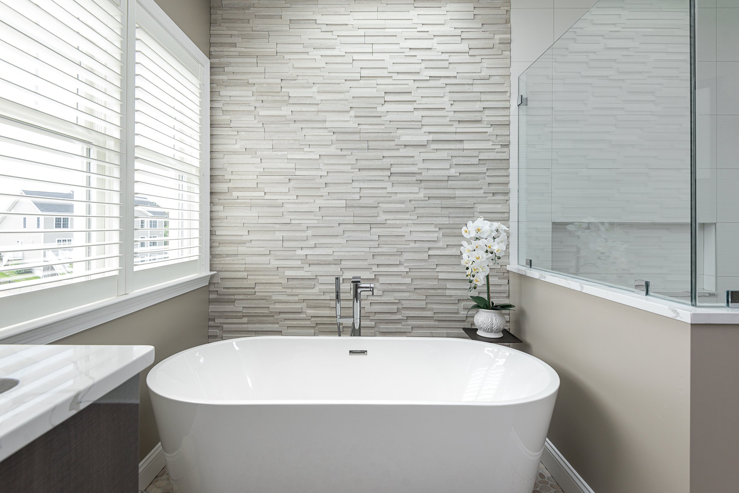 freestanding tub against stacked stone