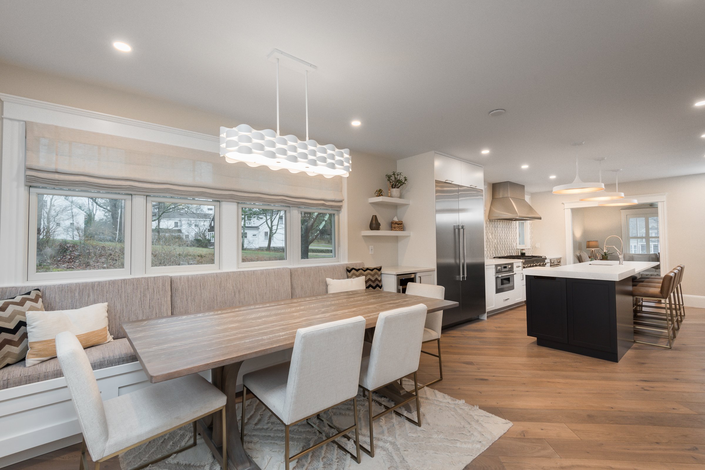 Breakfast nook with banquette seating, custom dining table, and integrated wine fridge