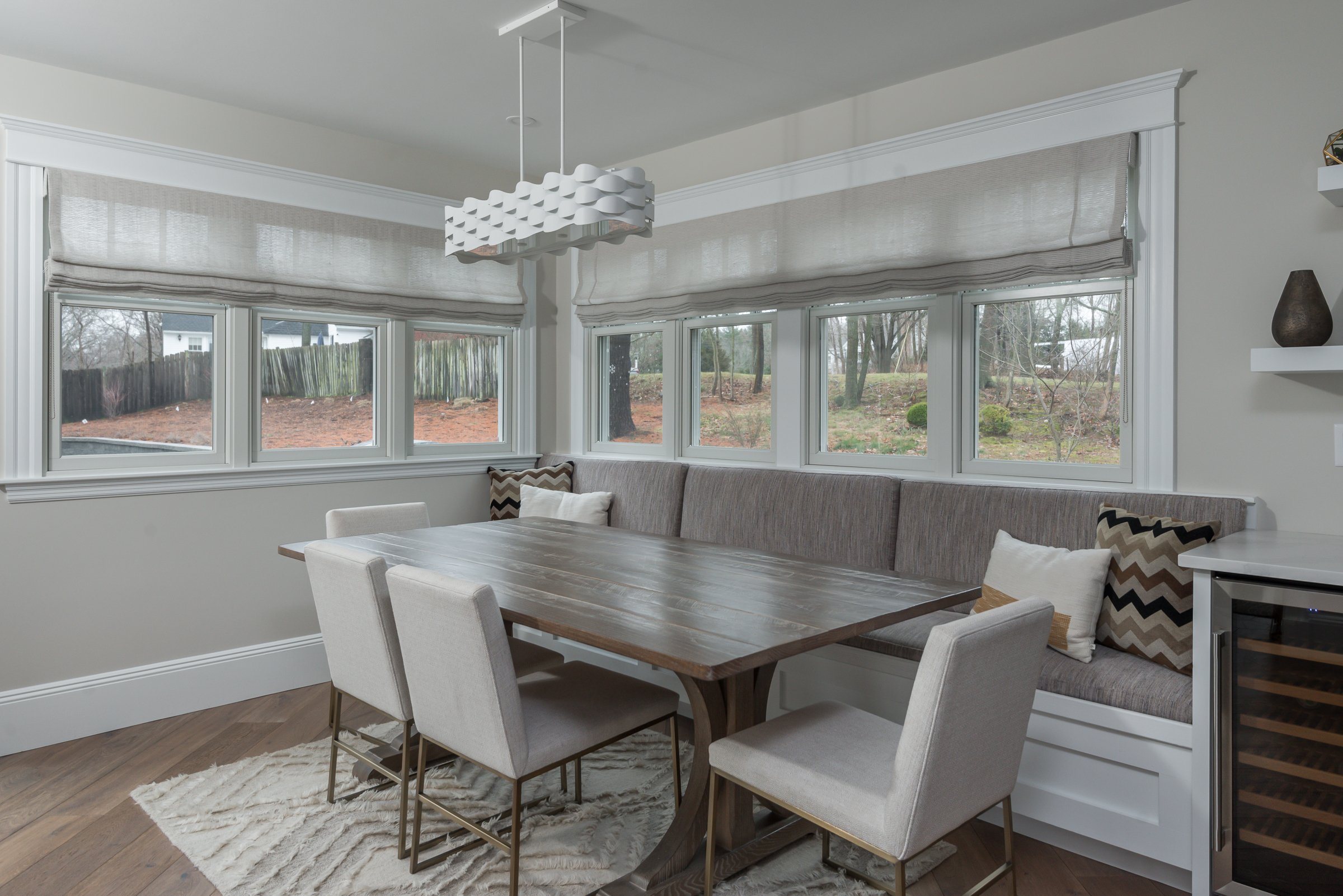 Custom built-in banquette with wine refrigerator, Coastal Currant pendant, and rear yard views