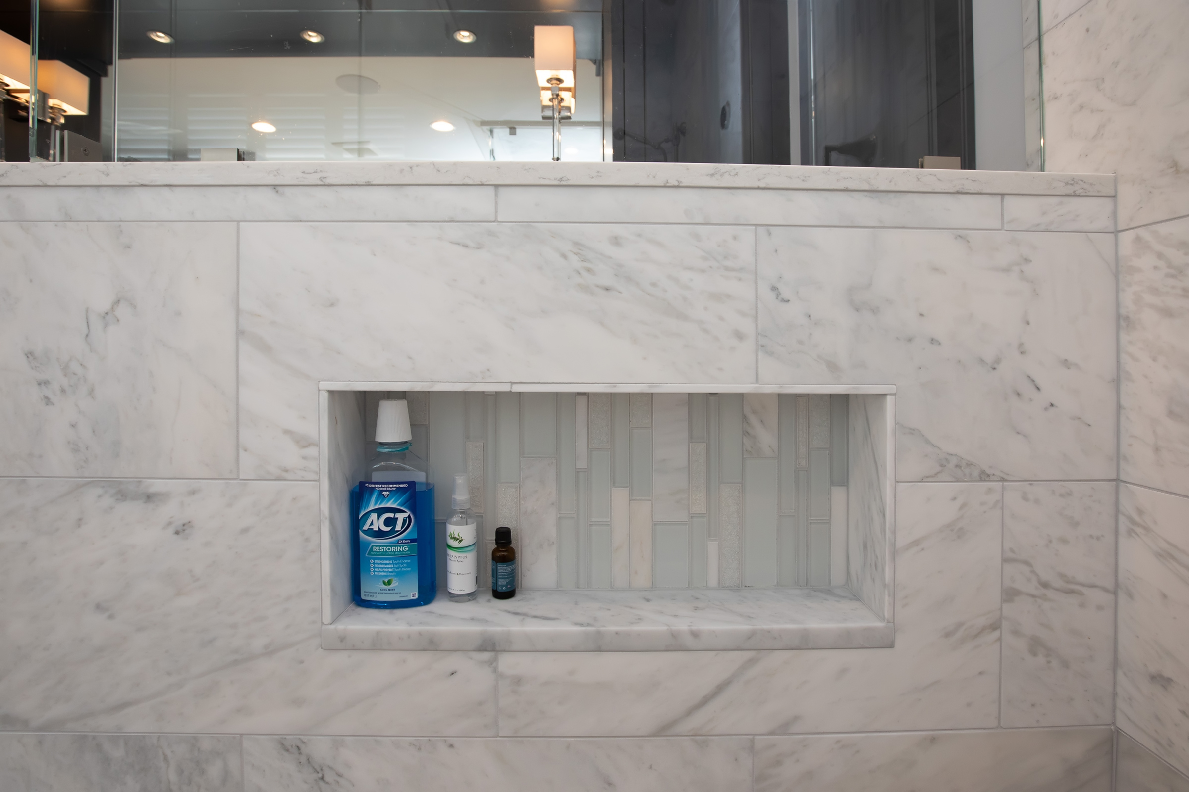 Marble shower niche with vertical glass mosaic accent in the Hingham primary bath