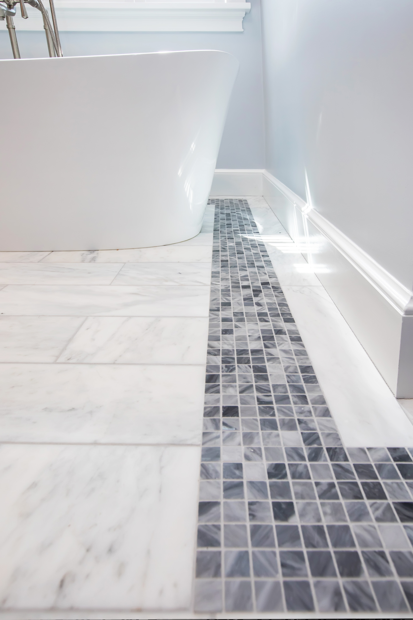 Grey marble mosaic tile border at the floor in the Hingham primary bath