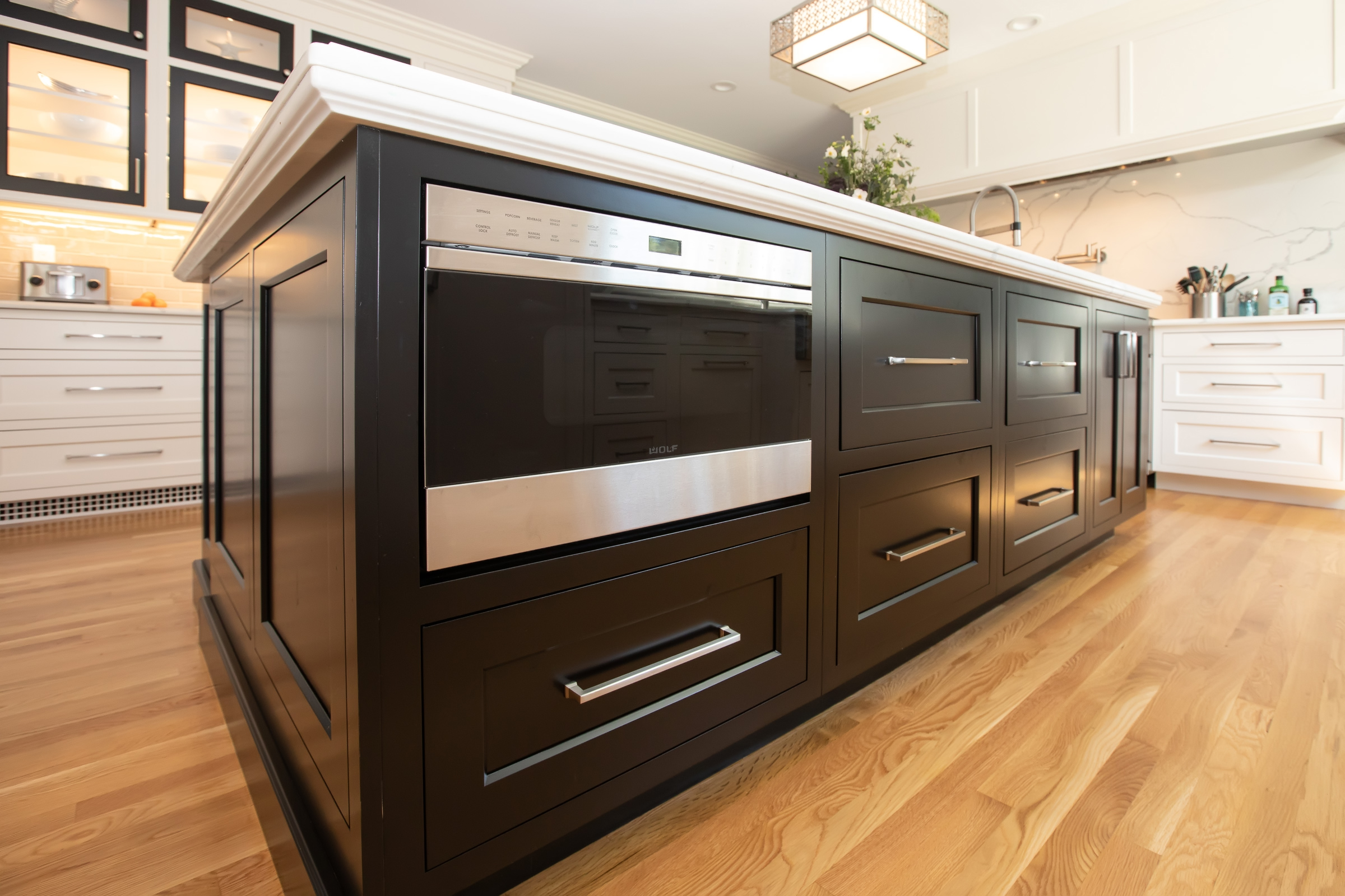 Dark wood Mouser kitchen island with built-in microwave and engineered quartz countertop in Hingham