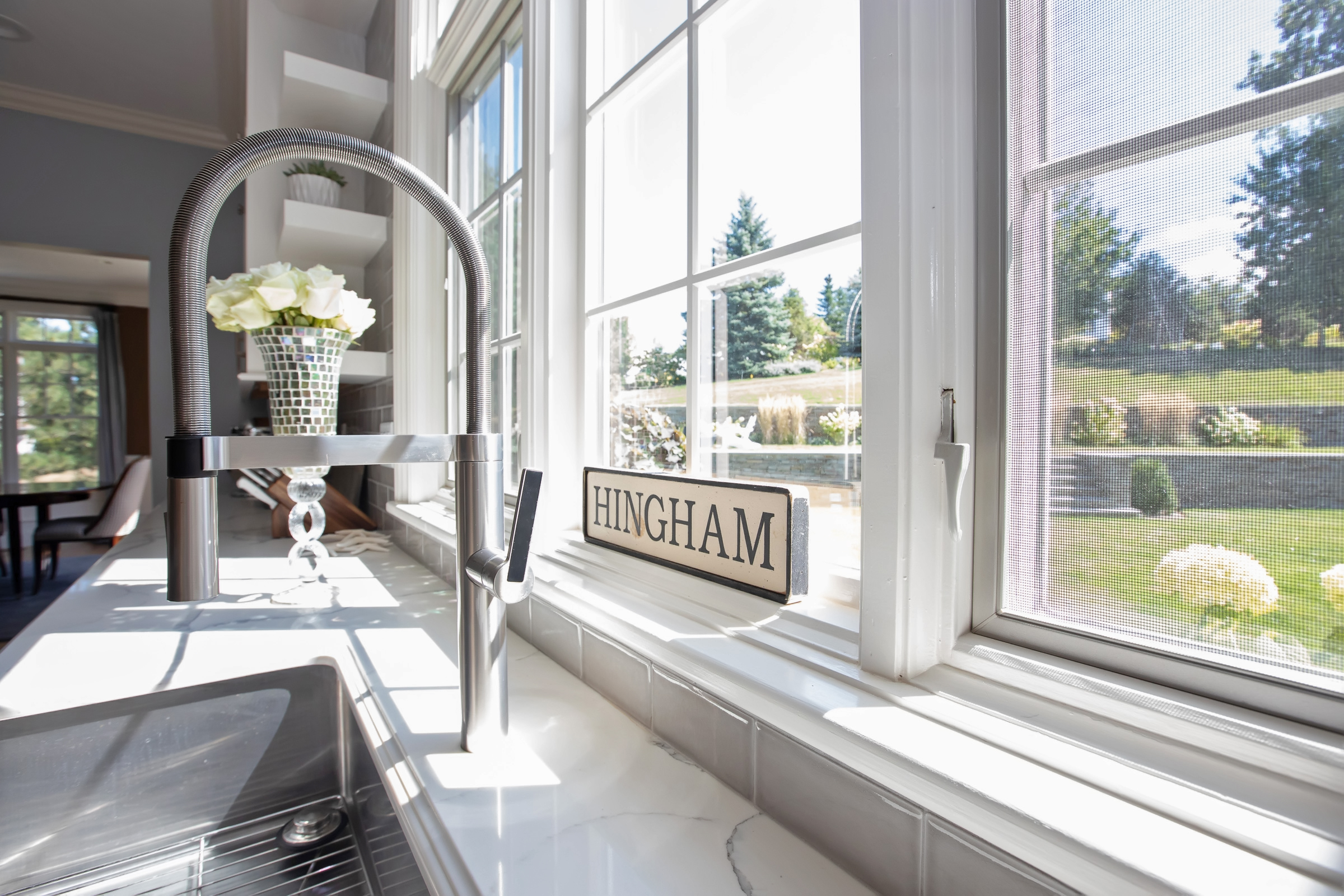 Kohler Vault farmhouse sink with Blanco Culina faucet under the window in the Hingham kitchen