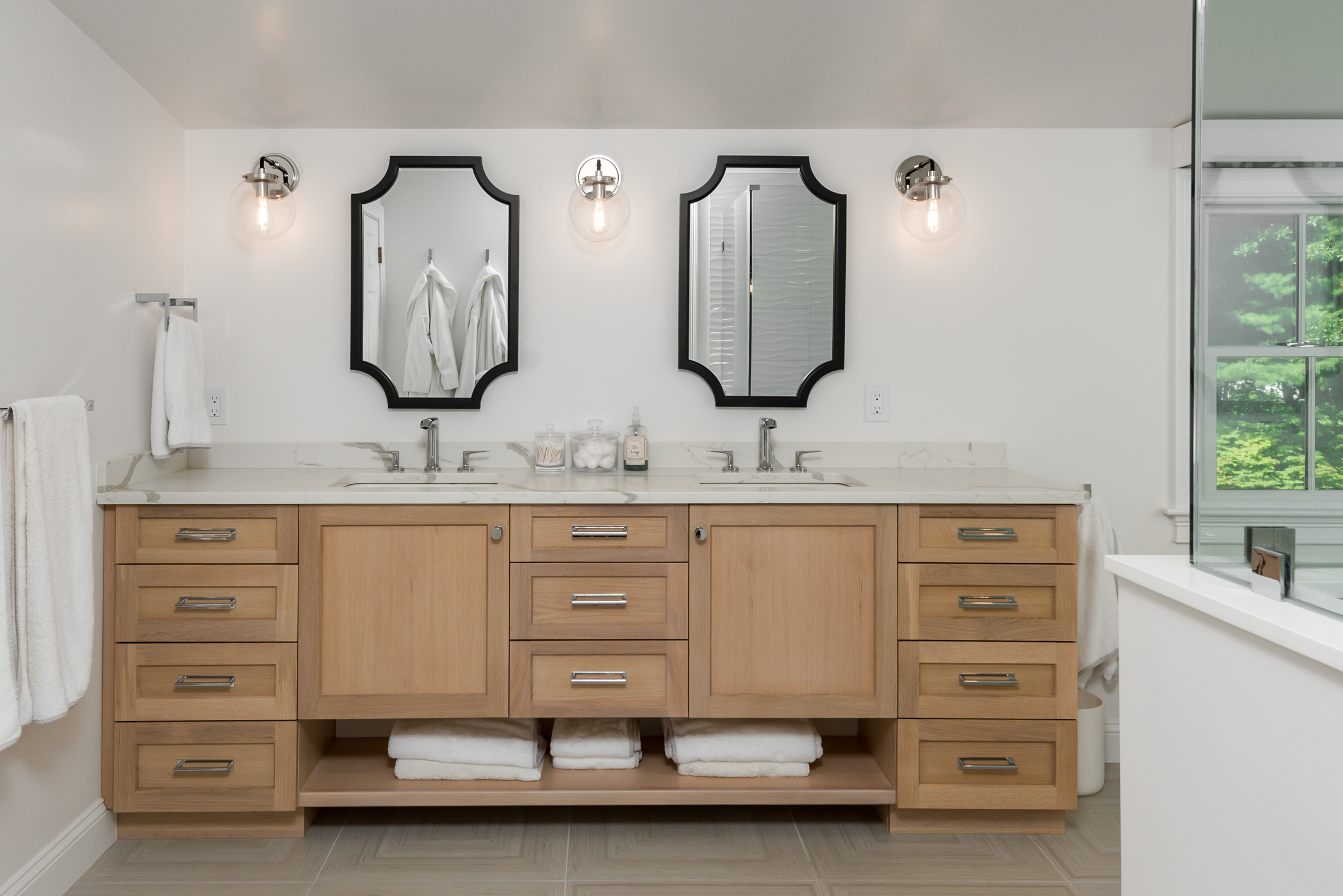 White oak double vanity with Calacatta quartz counters and scalloped black mirrors in the Norwell primary bath