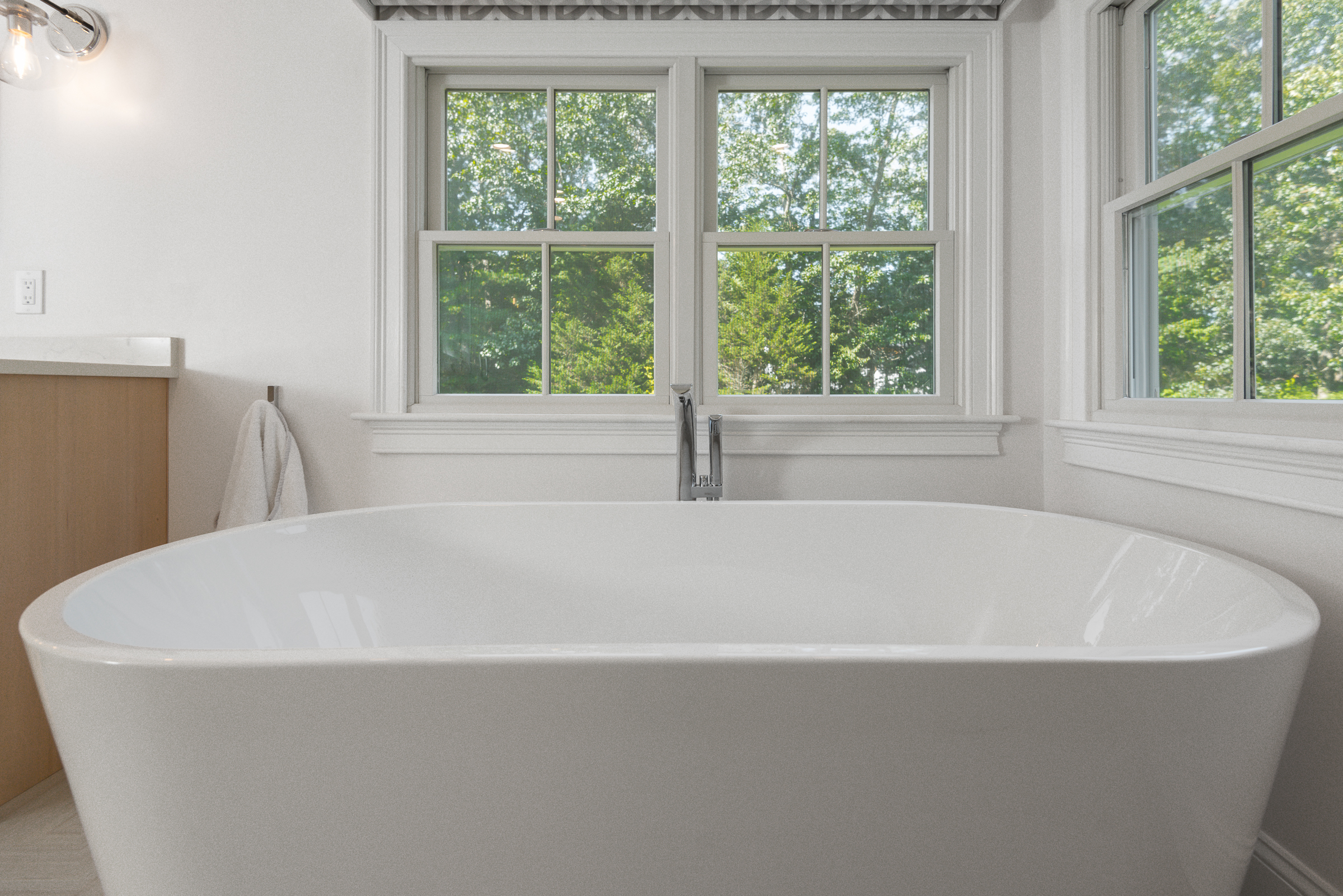 Maax Louis freestanding tub beneath the windows in the Norwell primary bath