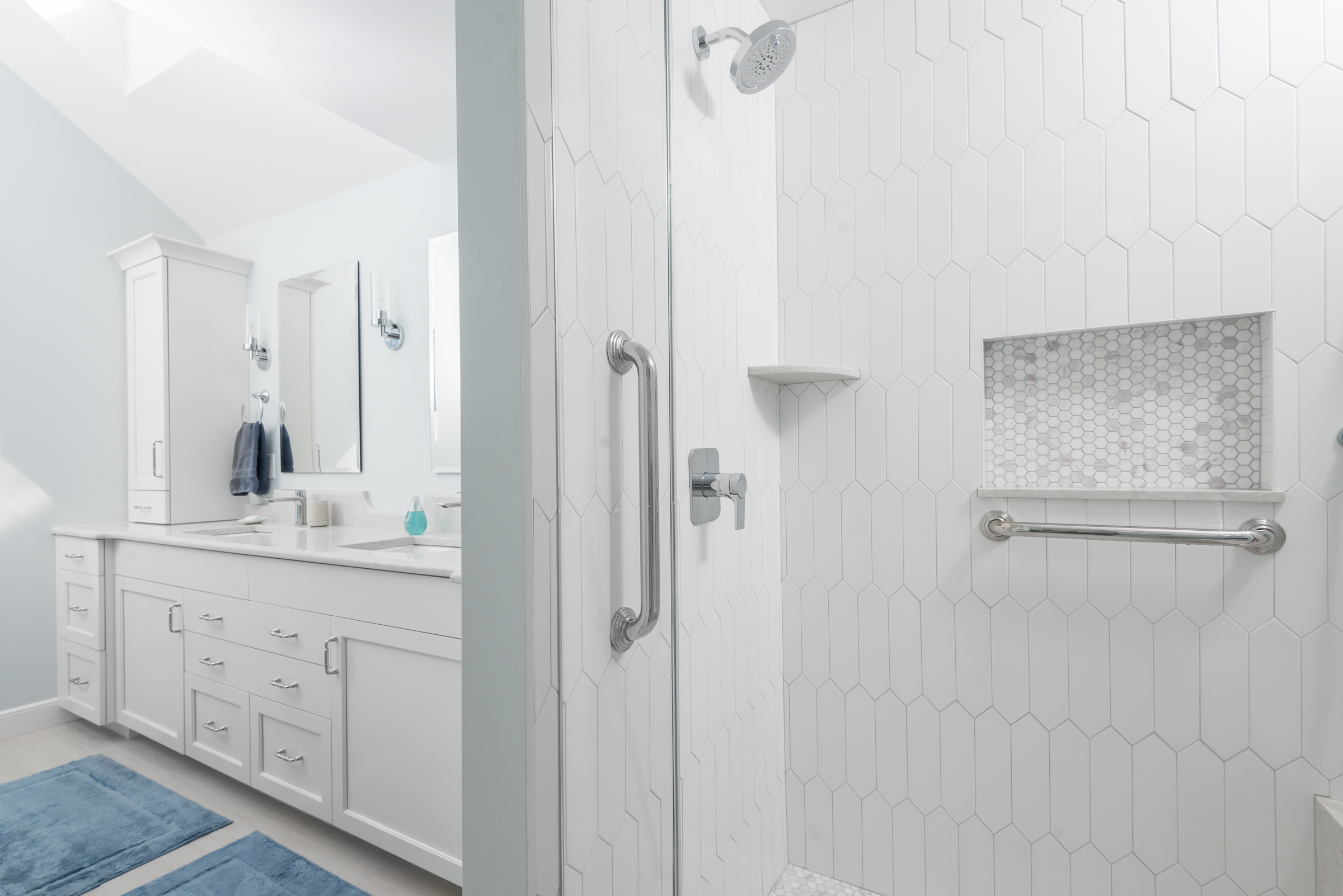 White picket tile shower with marble hex niche and built-in seat in the Hingham coastal primary bath
