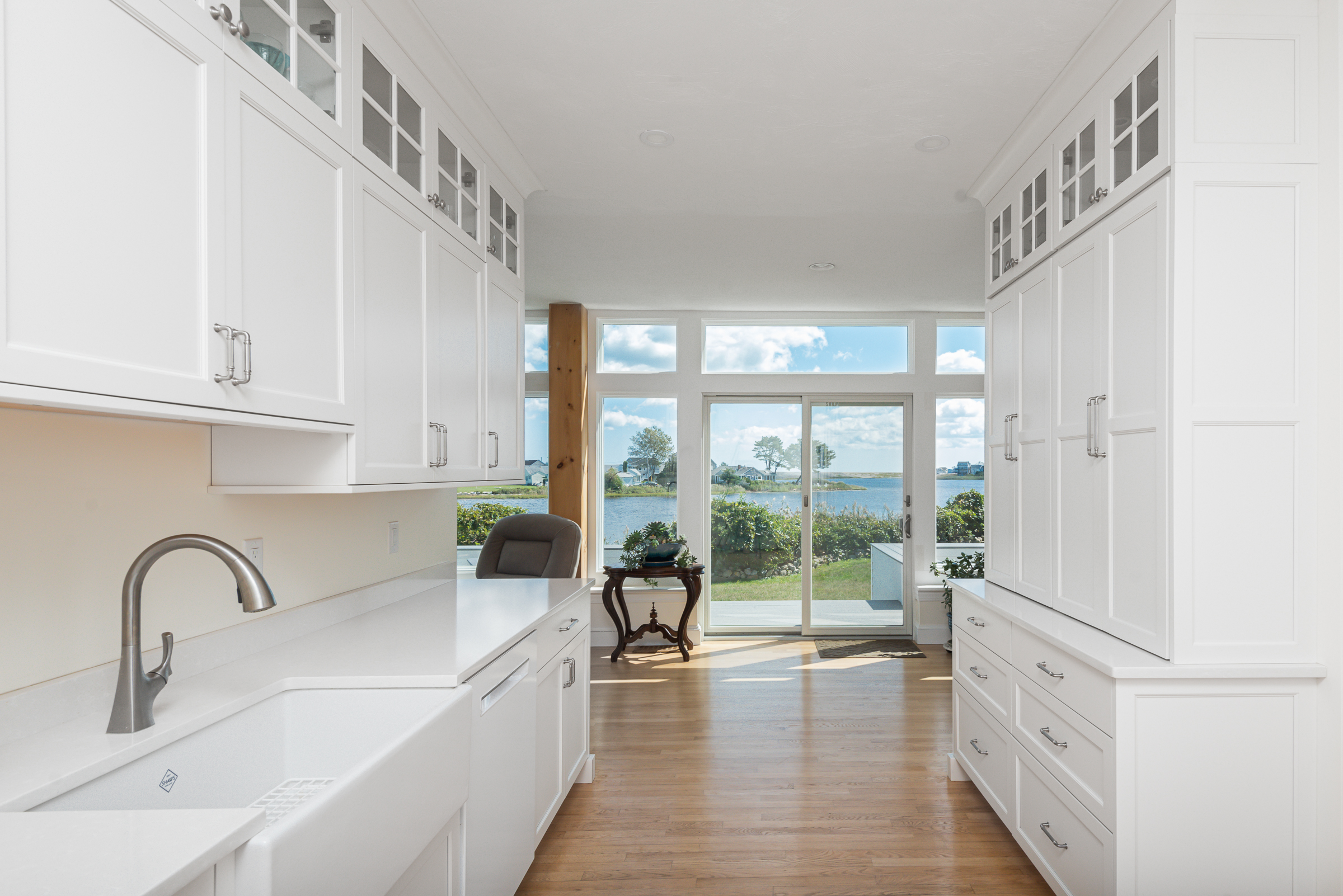 Scituate waterfront kitchen looking toward the sliders with farmhouse sink and water views