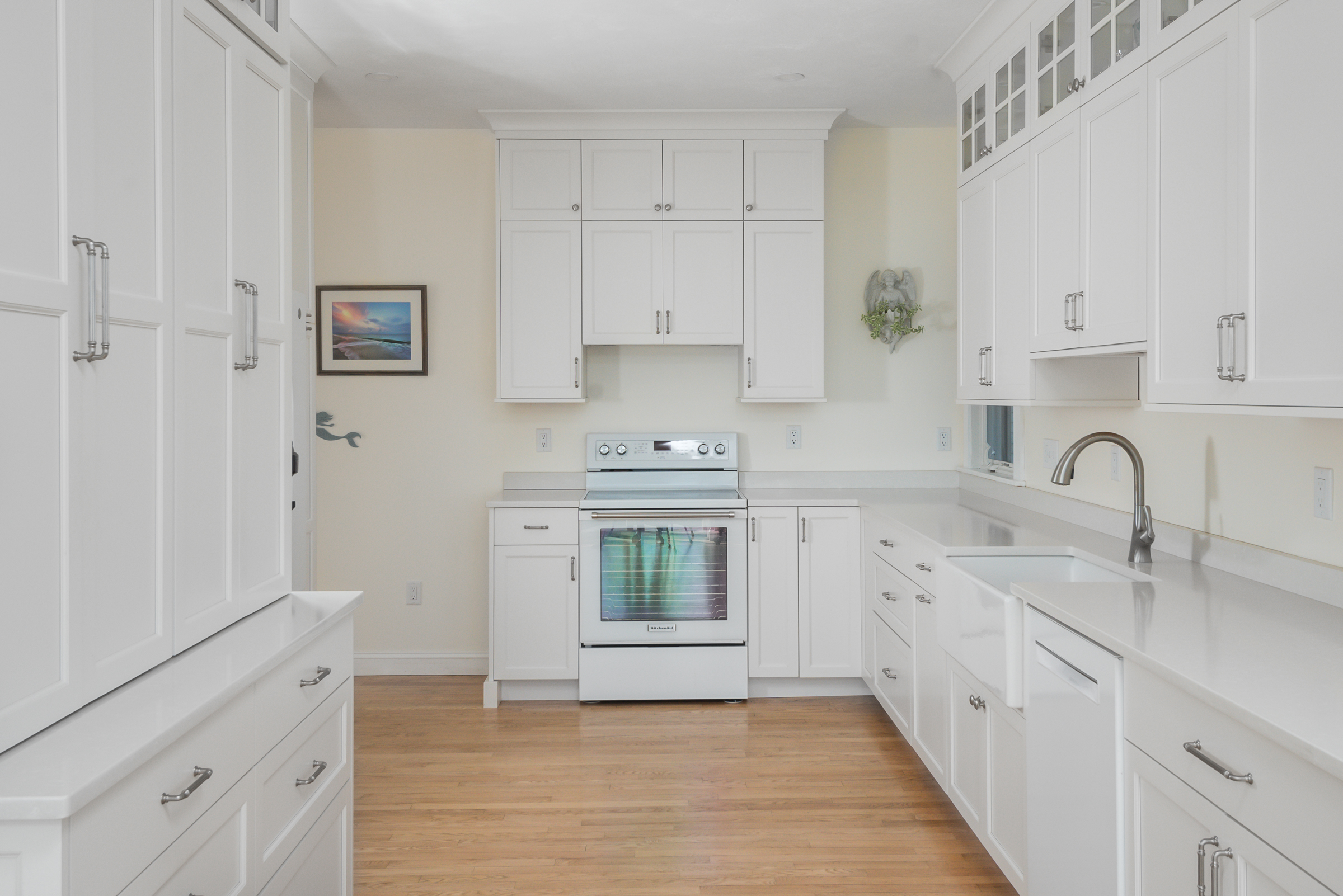White Mouser kitchen with farmhouse sink, range wall, and Silestone Yukon counters in Scituate