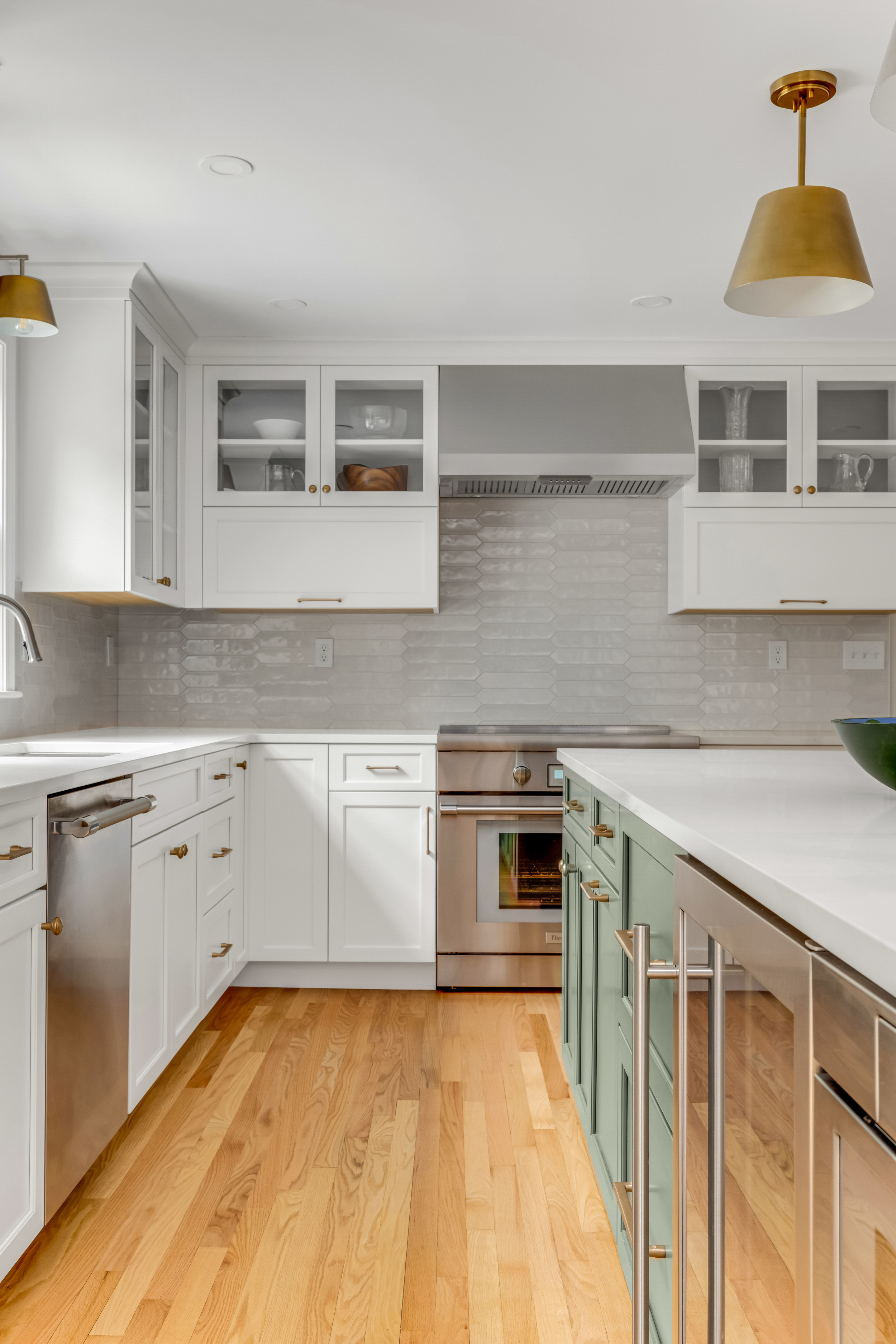 Picket tile backsplash with Thermador range and brass sconces