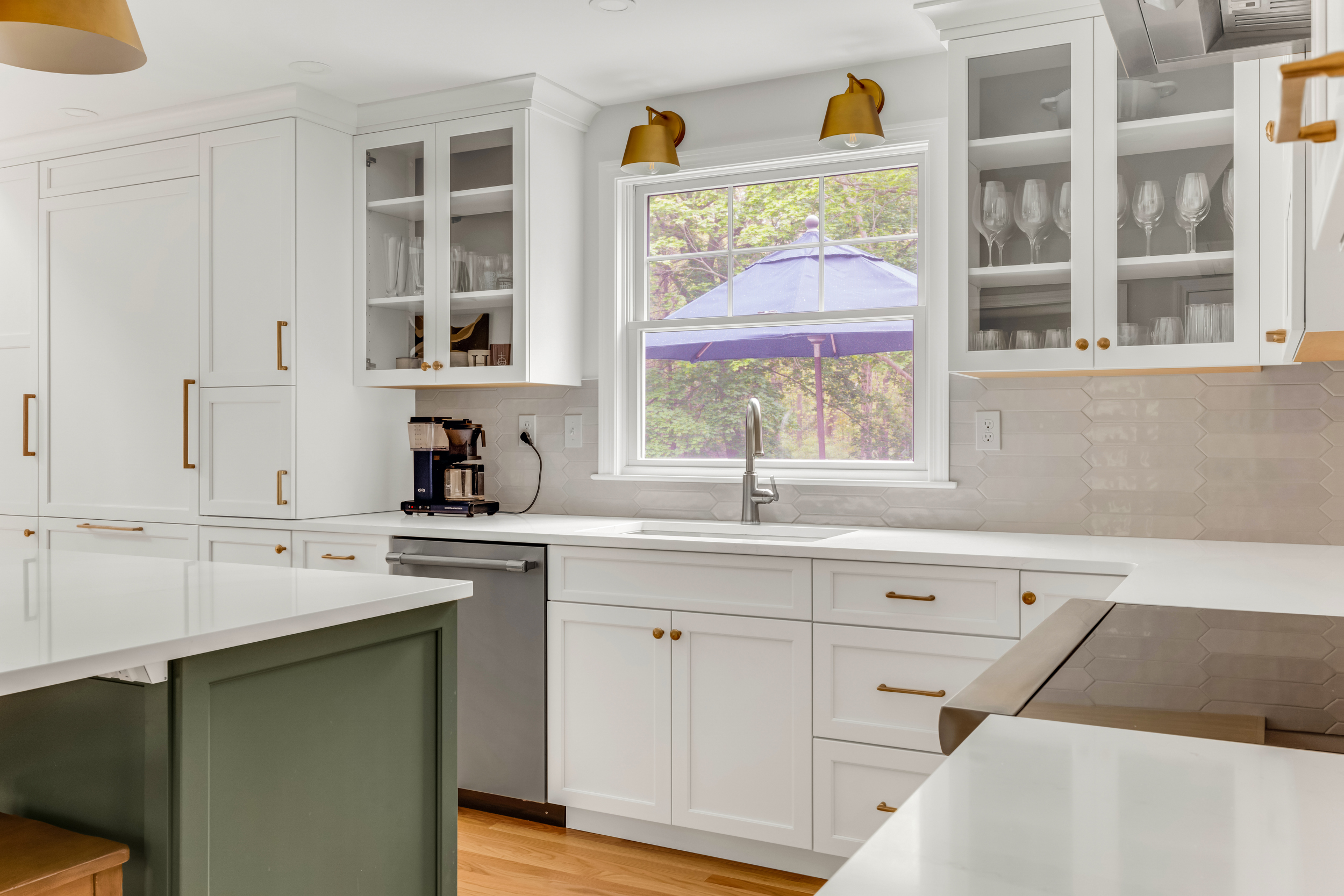 Kitchen sink wall with window, brass sconces, and dishwasher