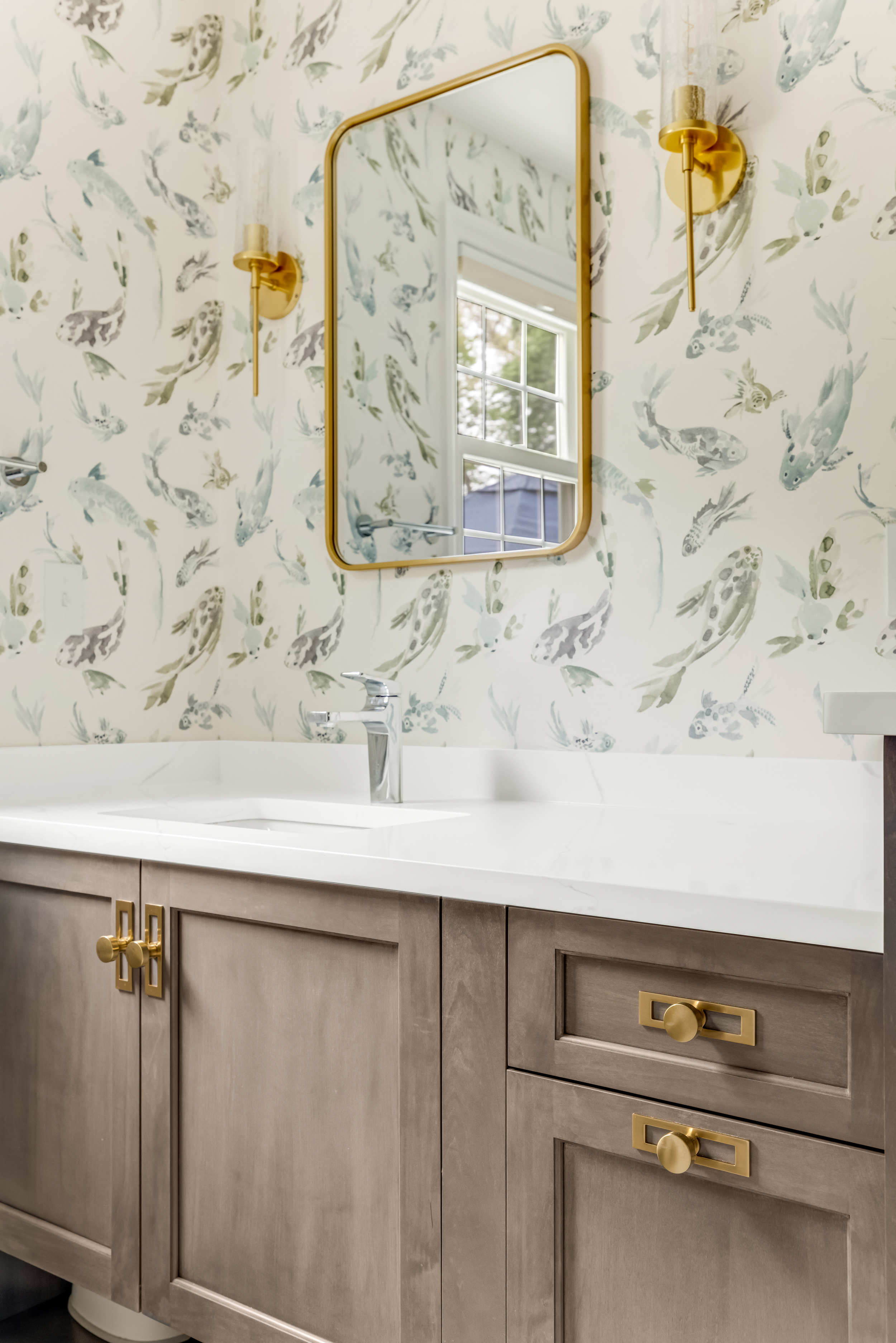 Half bath vanity with koi watercolor wallpaper, brass mirror, and quartz counter