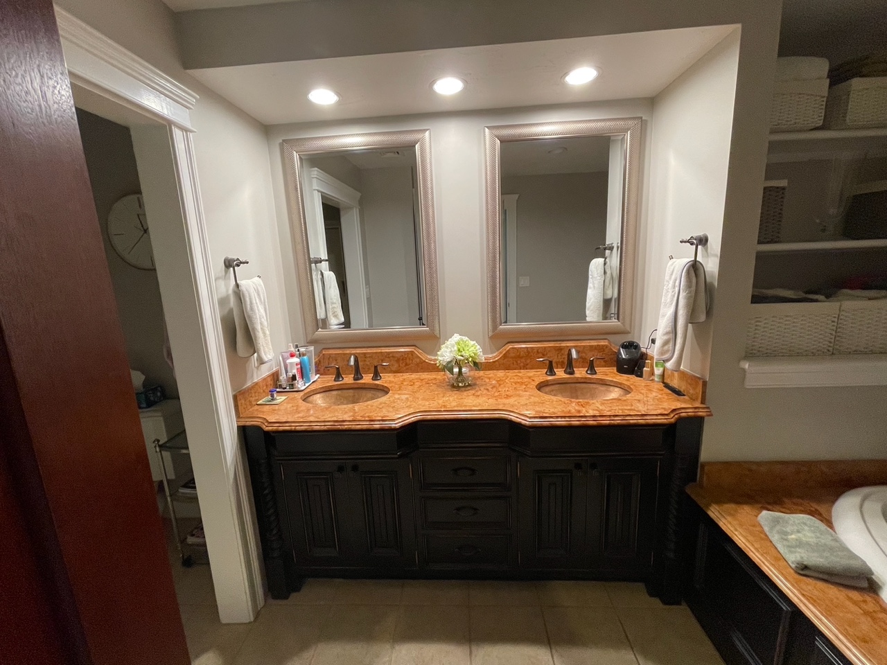 Before renovation: the original Braintree primary bath with a black raised-panel double vanity and burl-pattern marble countertop.