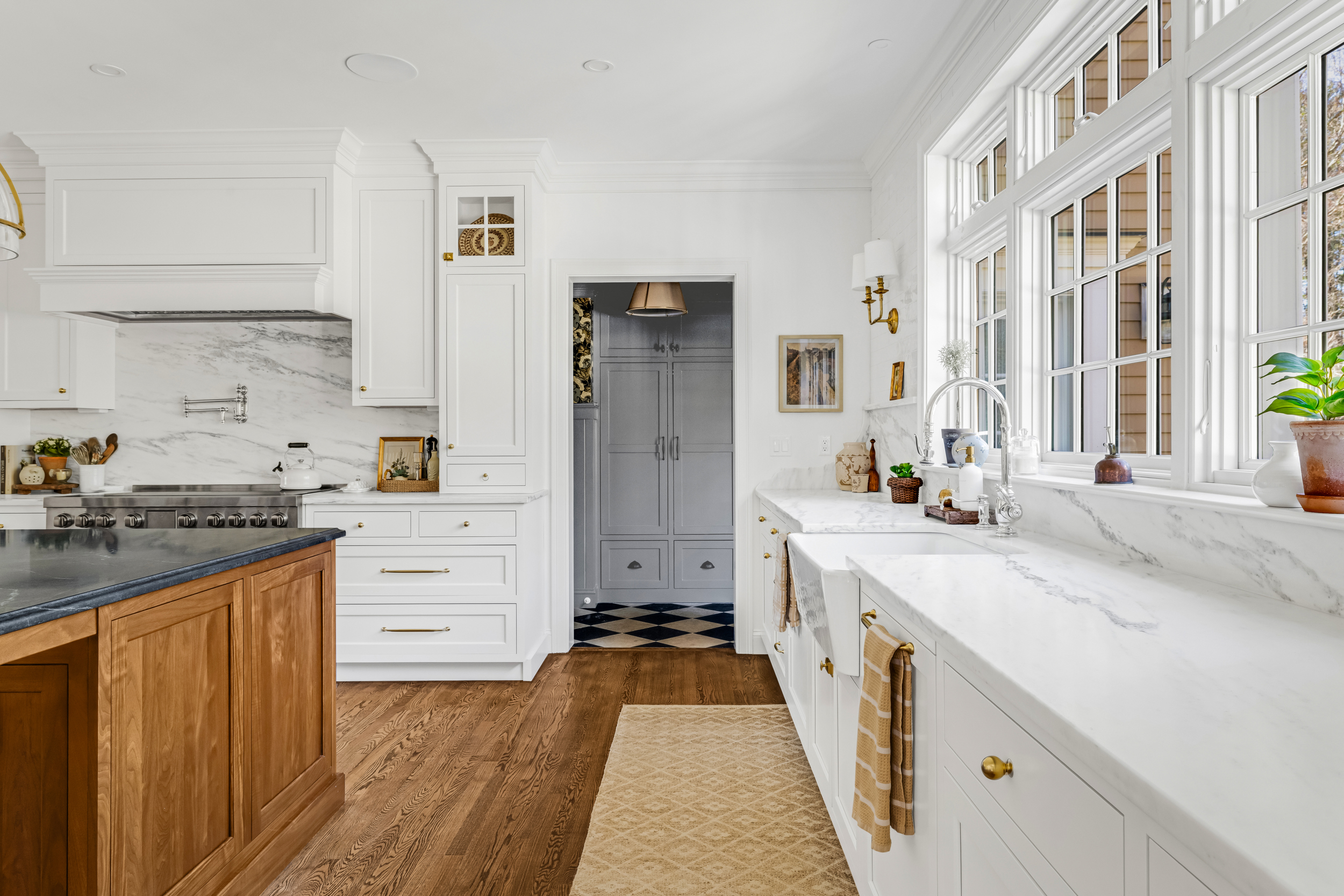 Wood kitchen island with seating and brass pendant lighting in Norwell