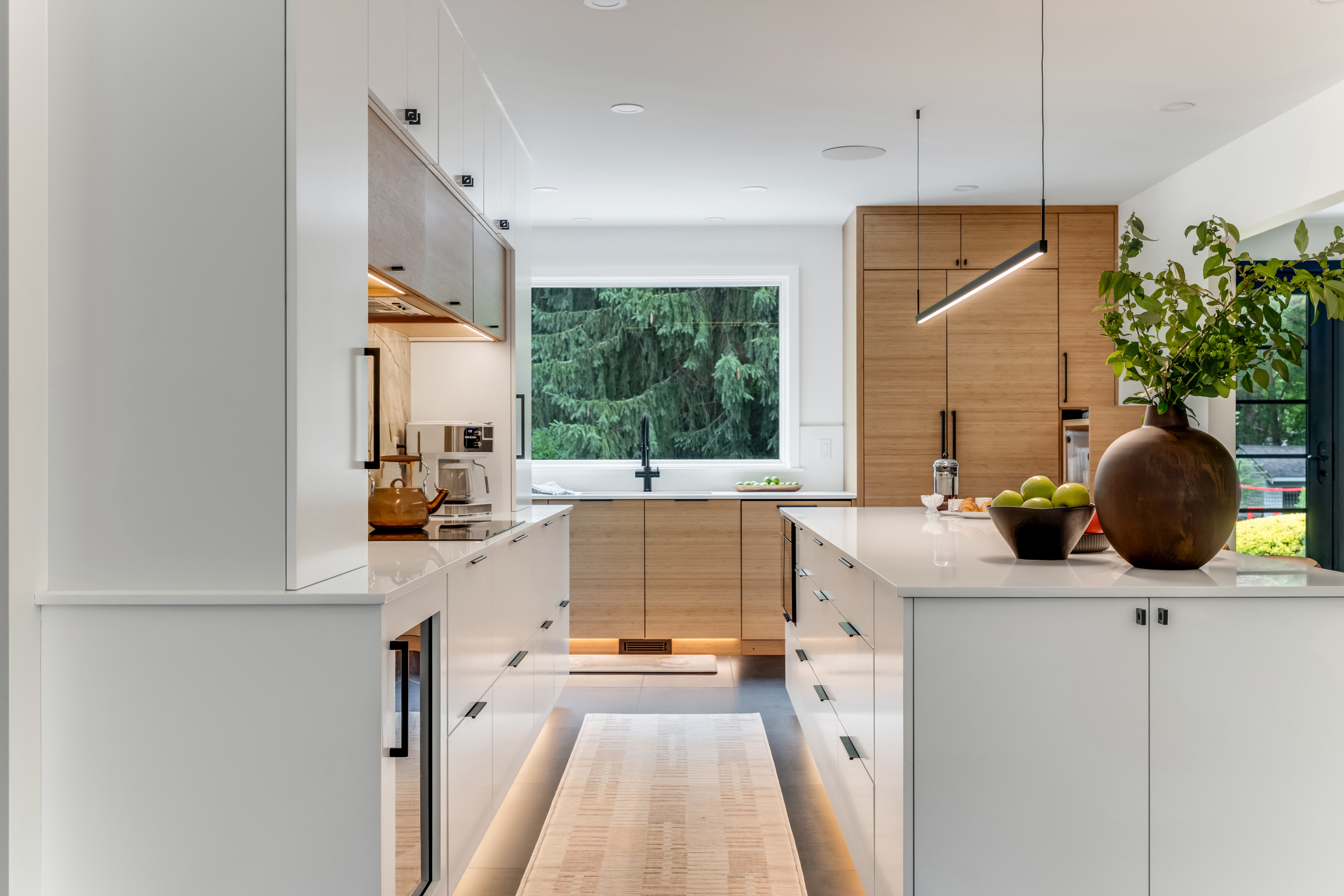 Large picture window over a stainless kitchen sink with wooded backyard views in a Marshfield remodel