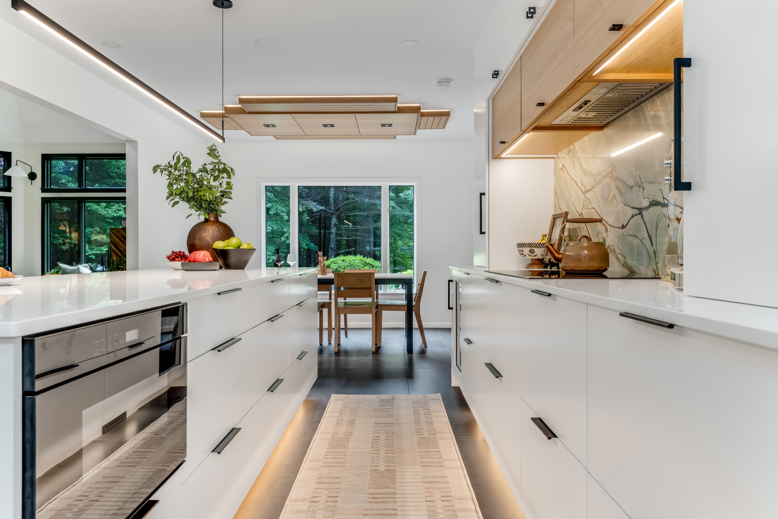 Waterfall quartz island with panel-ready beverage fridge opening to a two-story great room in a Marshfield first floor remodel