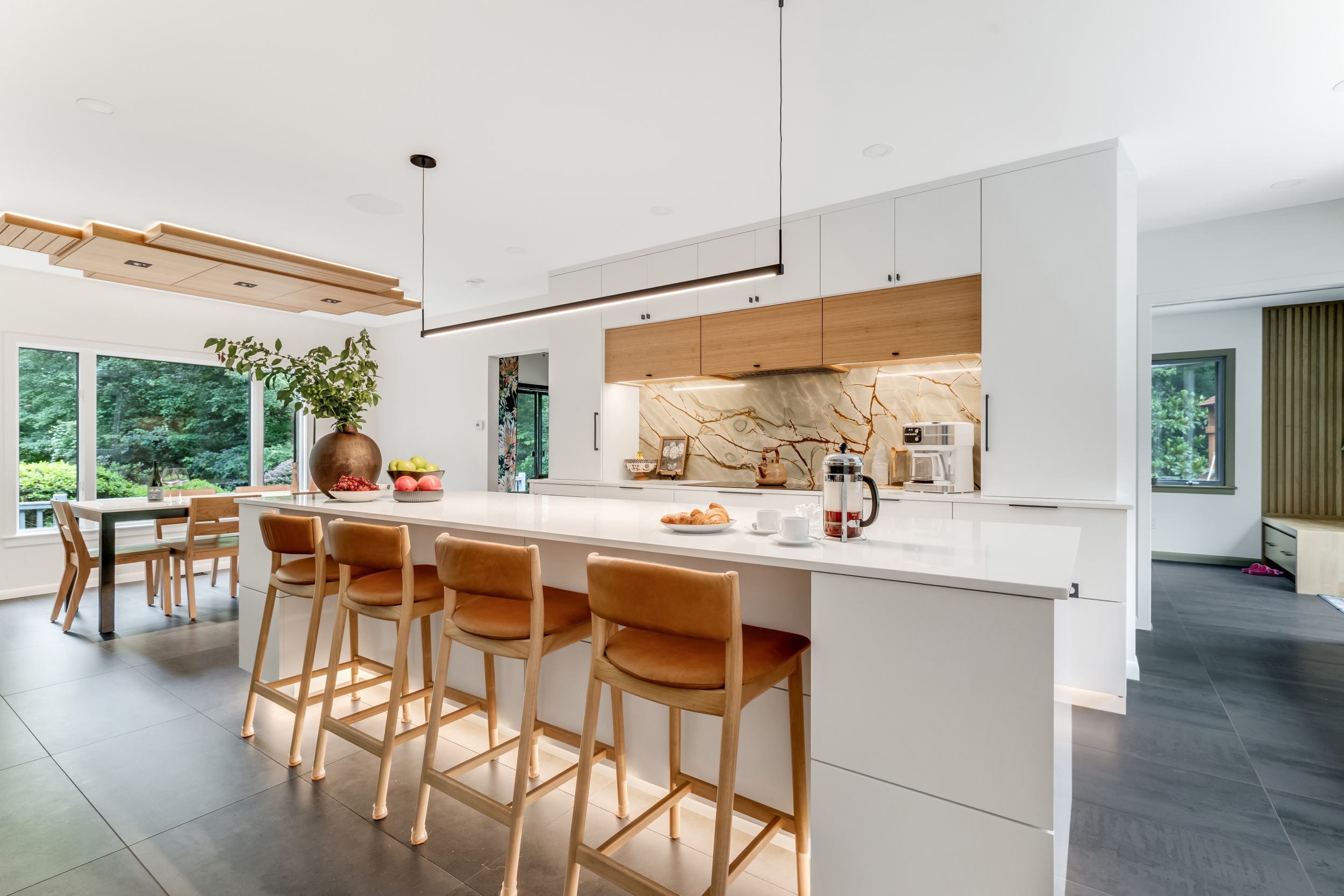 Single-slab granite backsplash behind the cooktop in a contemporary Marshfield kitchen with bamboo and white cabinetry