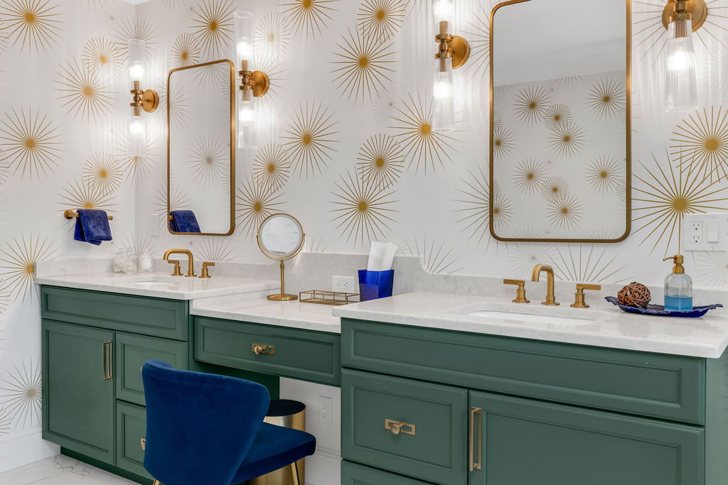 Double green vanities with a makeup station, brass faucets, and gold mirrors in a Hingham primary bath