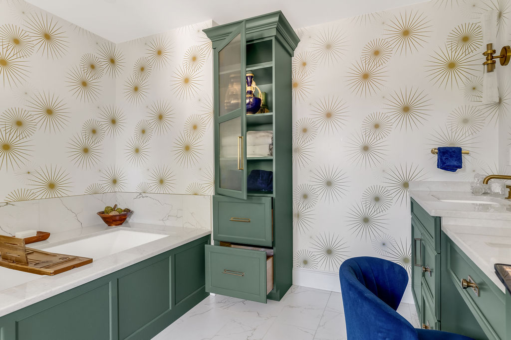 Green glass-front linen tower between the tub and vanity in a Hingham primary bath