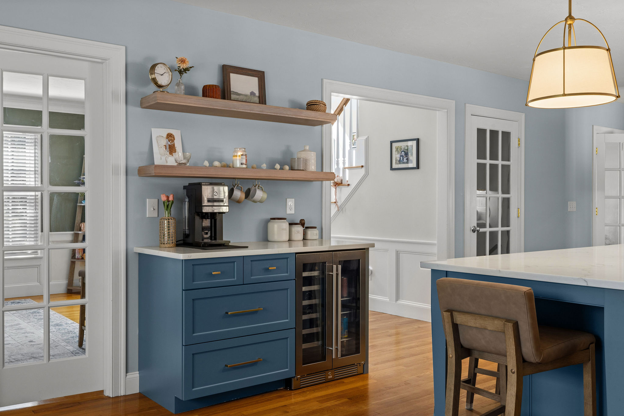 Seaglass coffee station with a beverage fridge, wood floating shelves, and brass hardware in a Hanover kitchen