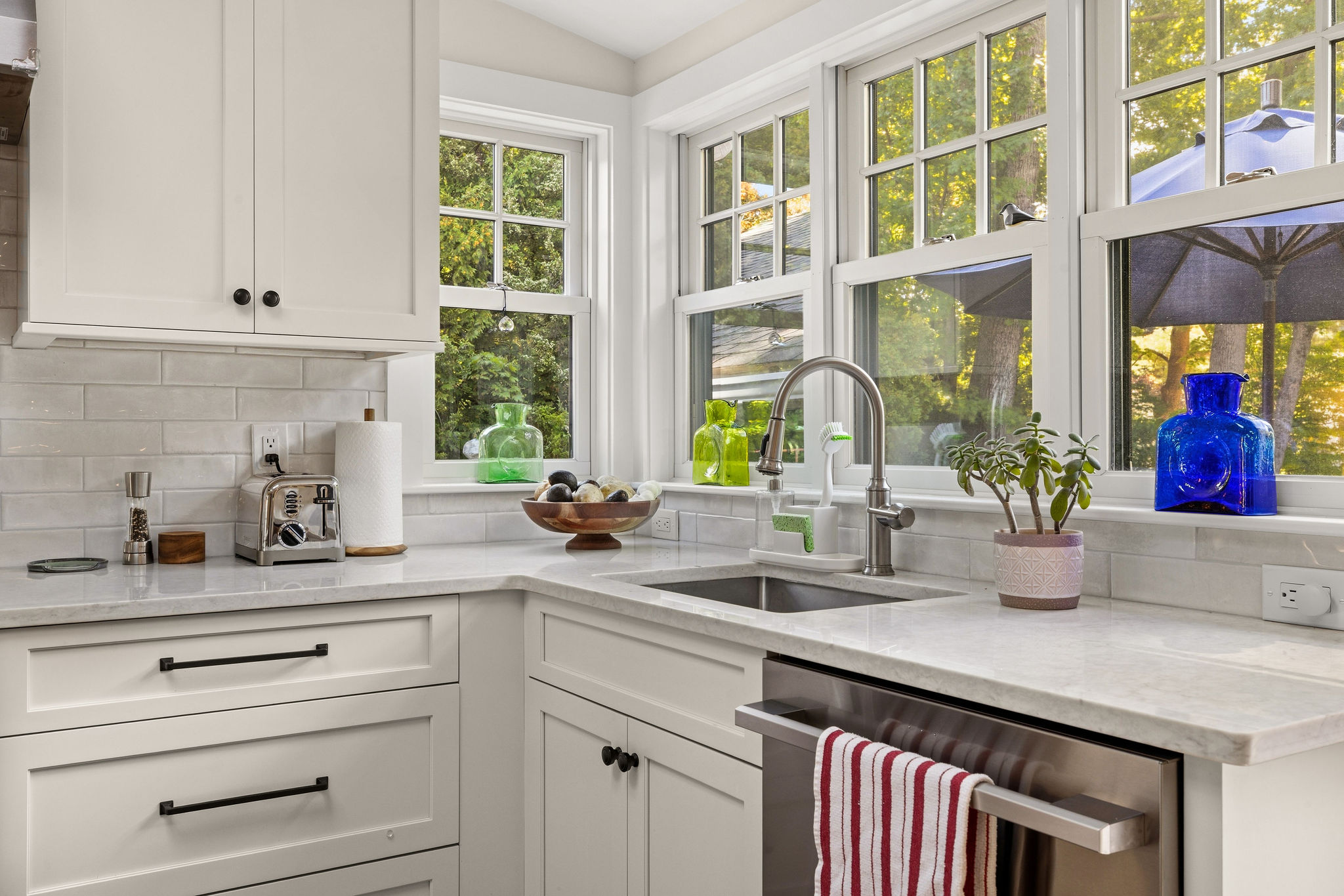 White kitchen remodel in Hingham with a vaulted ceiling, skylight, range, and quartz counters