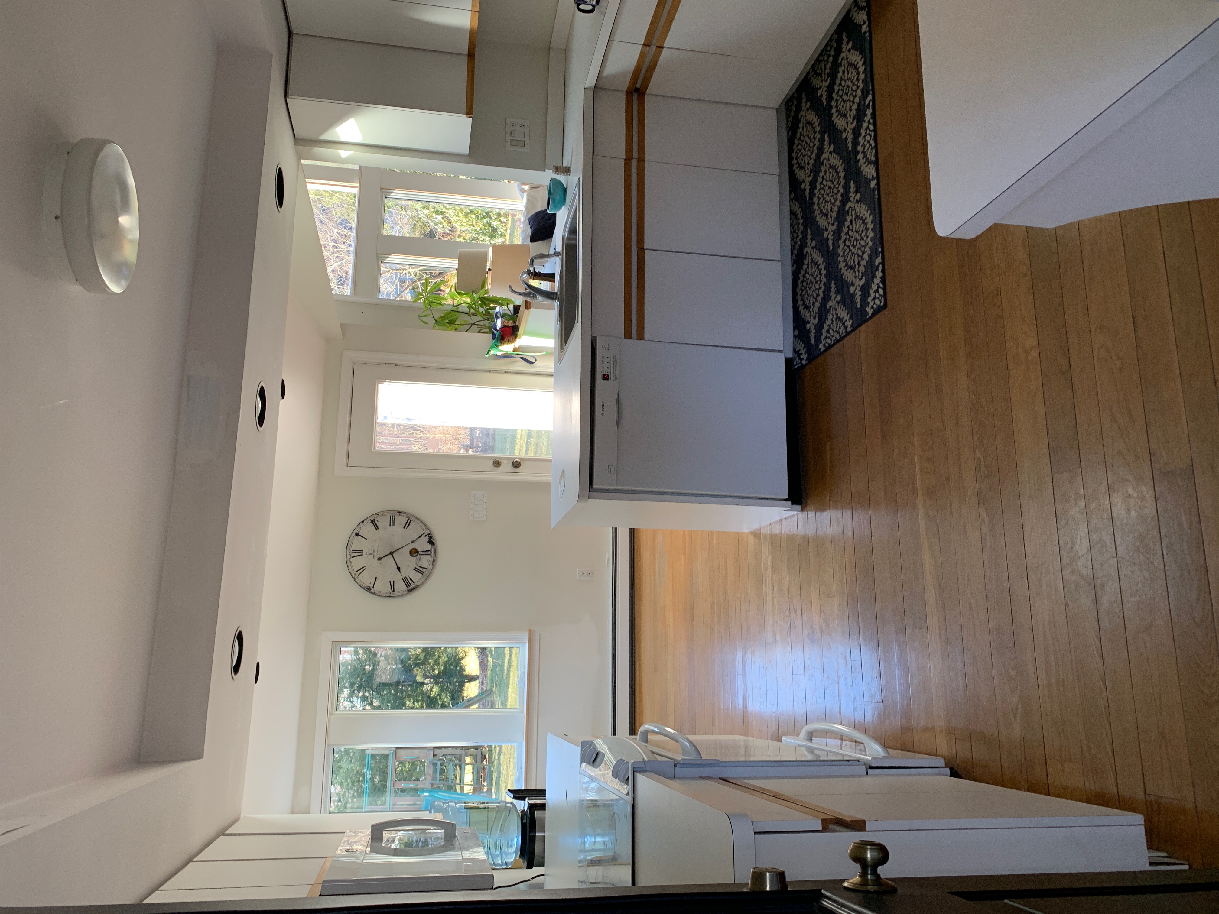 Before renovation: the original Hingham kitchen with white laminate cabinets, oak trim, and a bulkhead ceiling before the vault and skylight