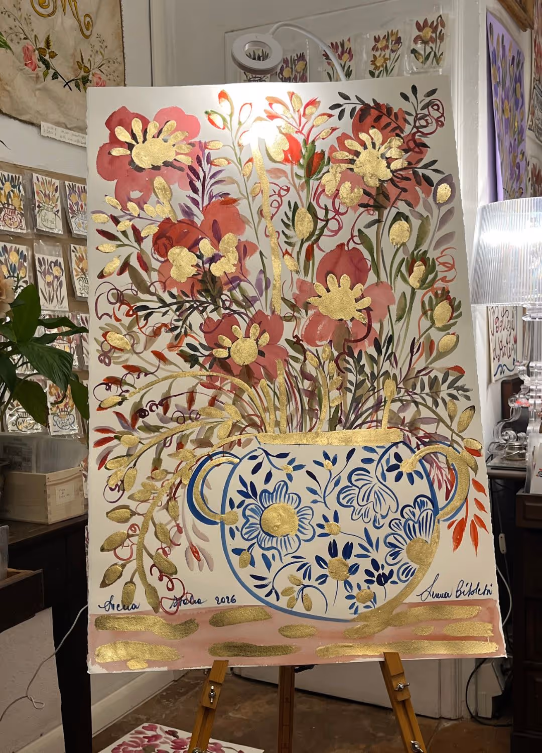 Maestoso floral painting of red tulips and gold leaf blooms, propped on an easel in the atelier.