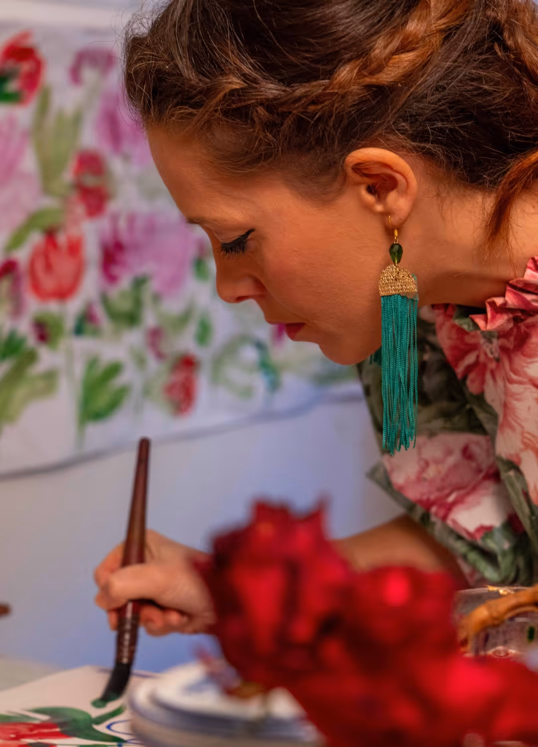 Serena Bifolchi painting in her Tuscan atelier, working on a floral piece on handmade paper.