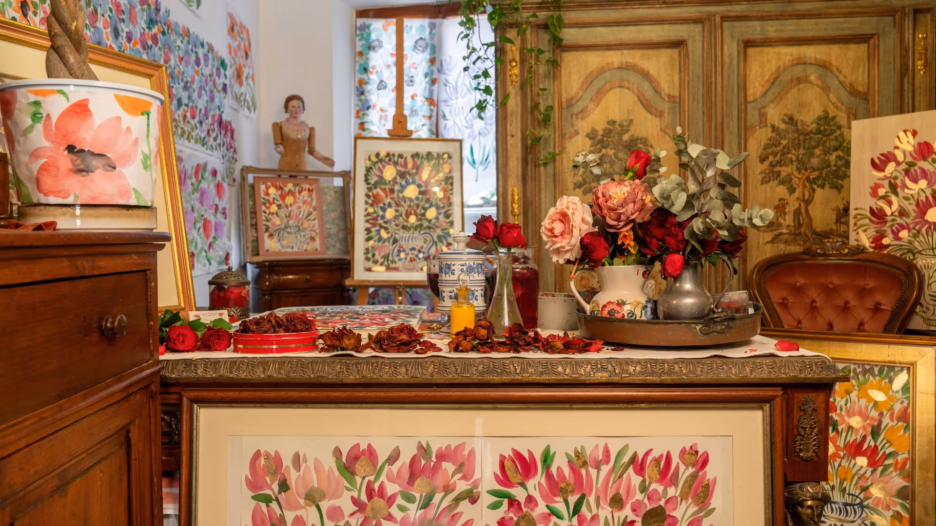 Interior of Serena Bifolchi's atelier — floral paintings, antique furniture, and a Victorian parlour atmosphere