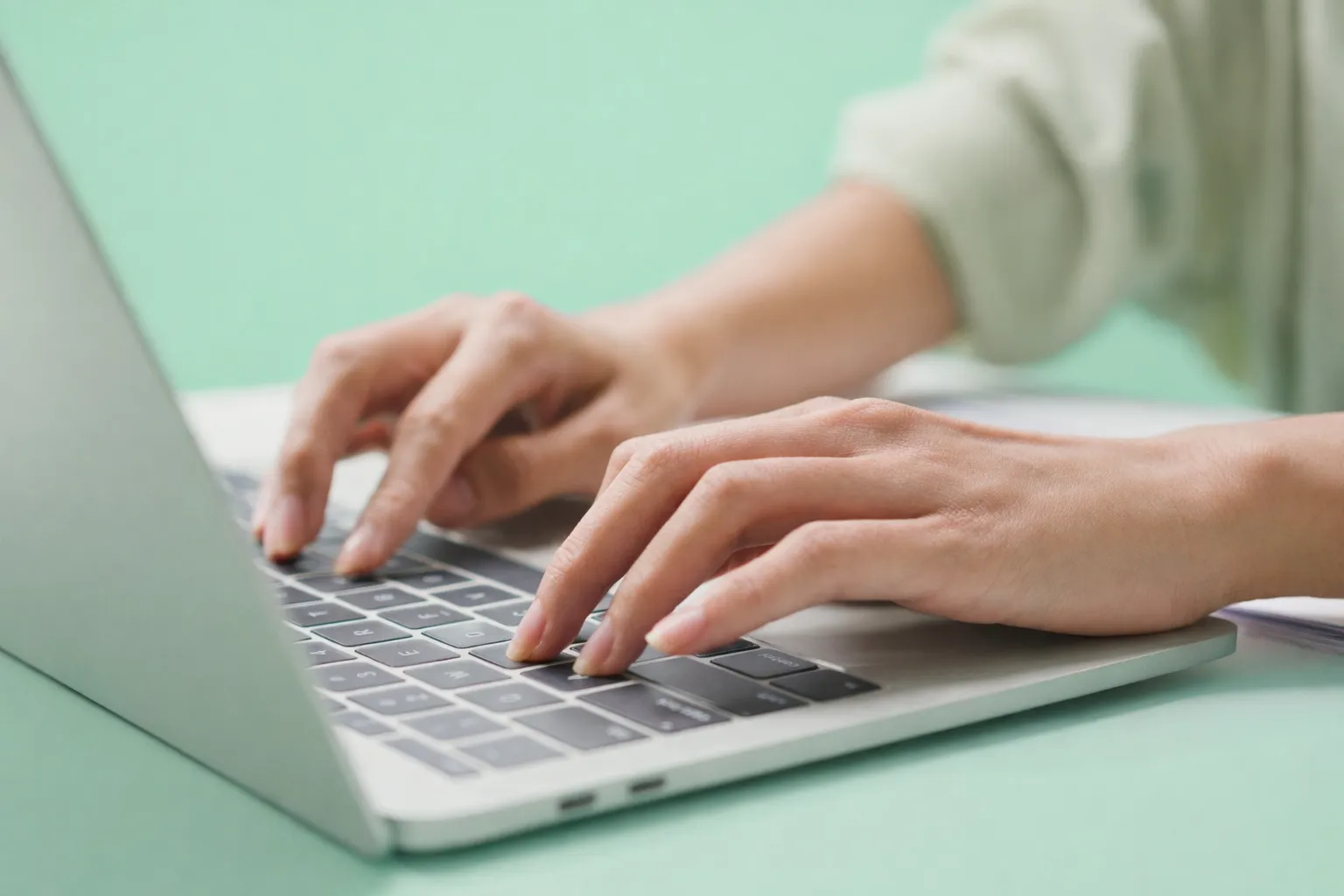 Close-up of hands typing on a laptop