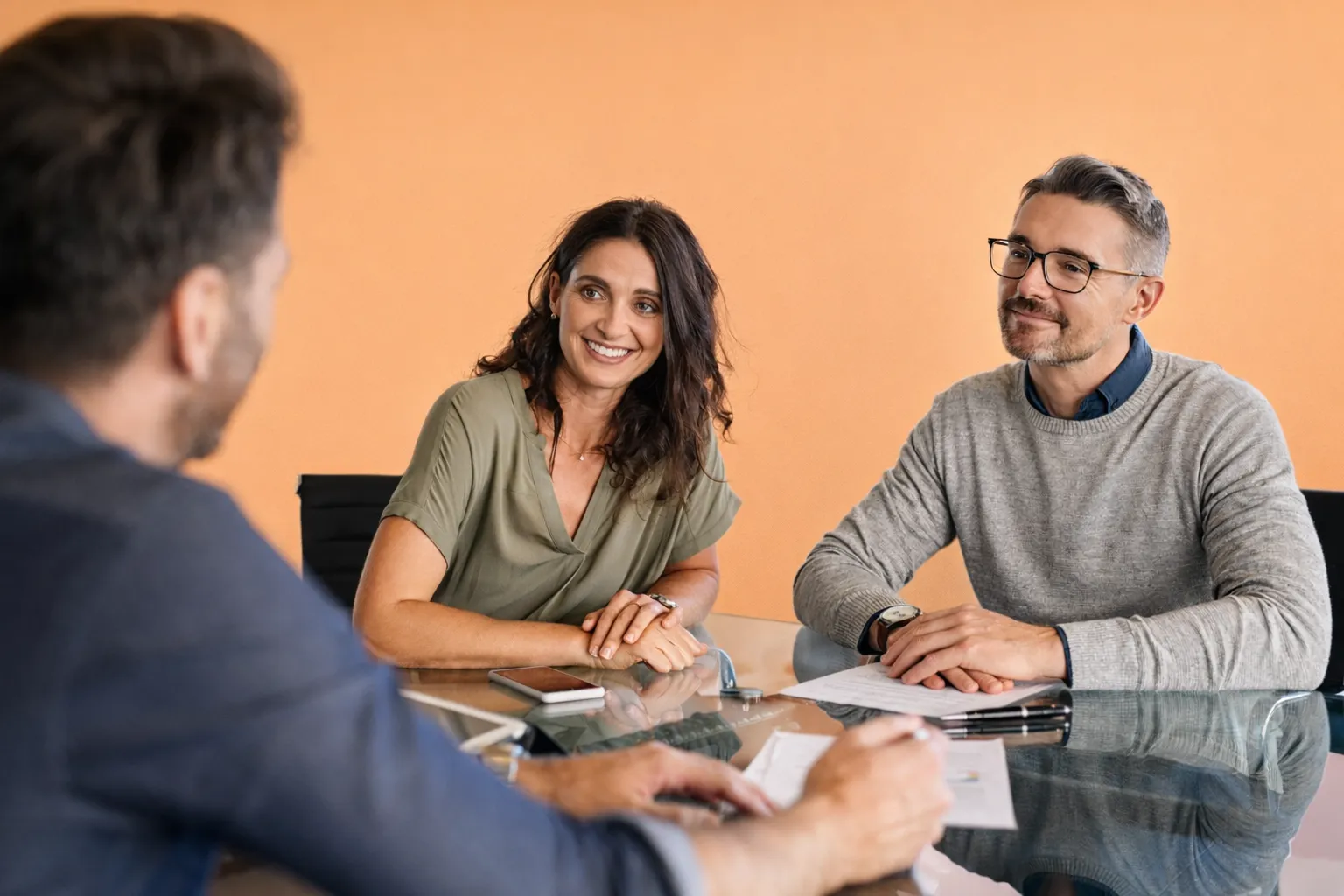Three colleagues in discussion around a meeting table