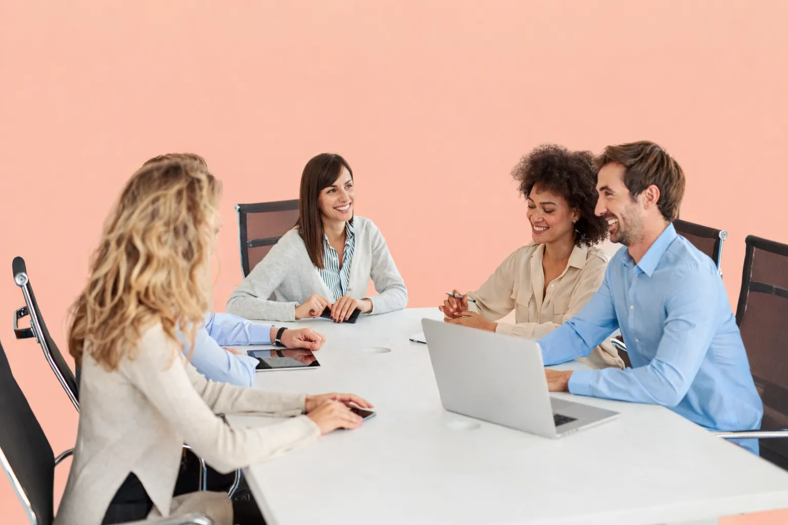 Team seated around a table with laptops