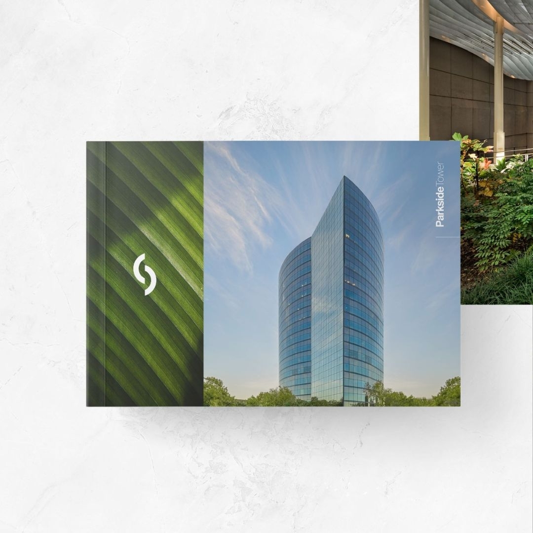 Book cover with a glass office tower under a blue sky and green leaf design on the left side.