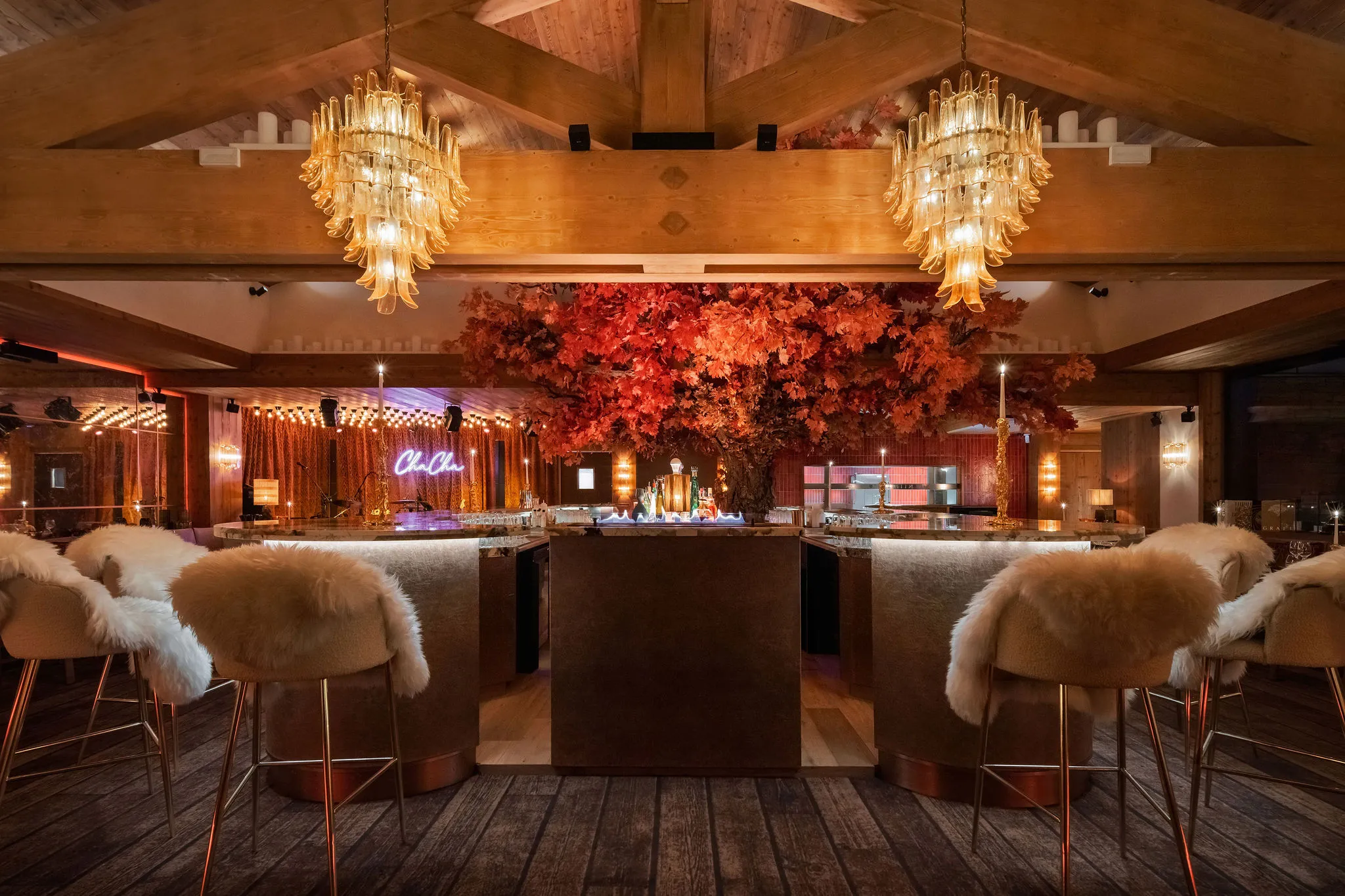 Vue frontale du bar iconique et de son arbre décoratif au restaurant ChaCha, propriété du groupe Annie Famose (AFGroupe), dans un décor de chalet contemporain.