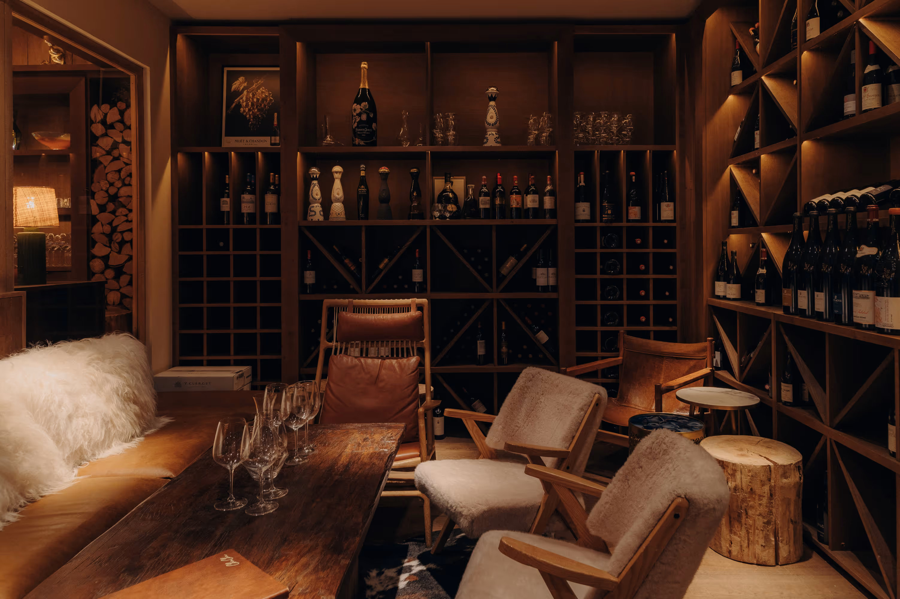 Intimate wine cellar space at the ChaCha restaurant, from the Annie Famose group (AFGroupe), with its wooden storage and comfortable sheepskin armchairs.