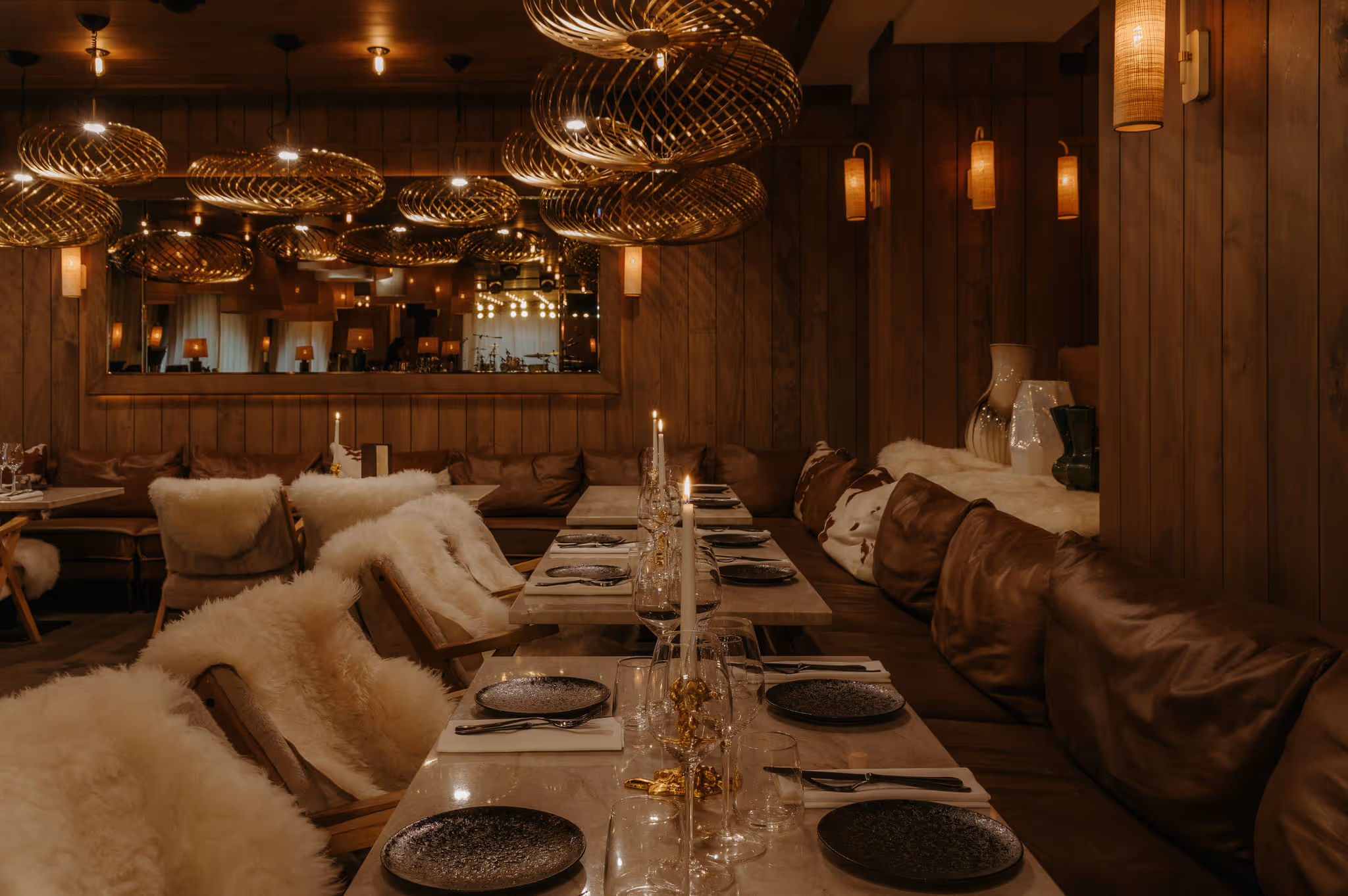 Chic and warm interior of the ChaCha restaurant, managed by the Annie Famose group (AFGroupe), featuring designer lighting and fur benches.