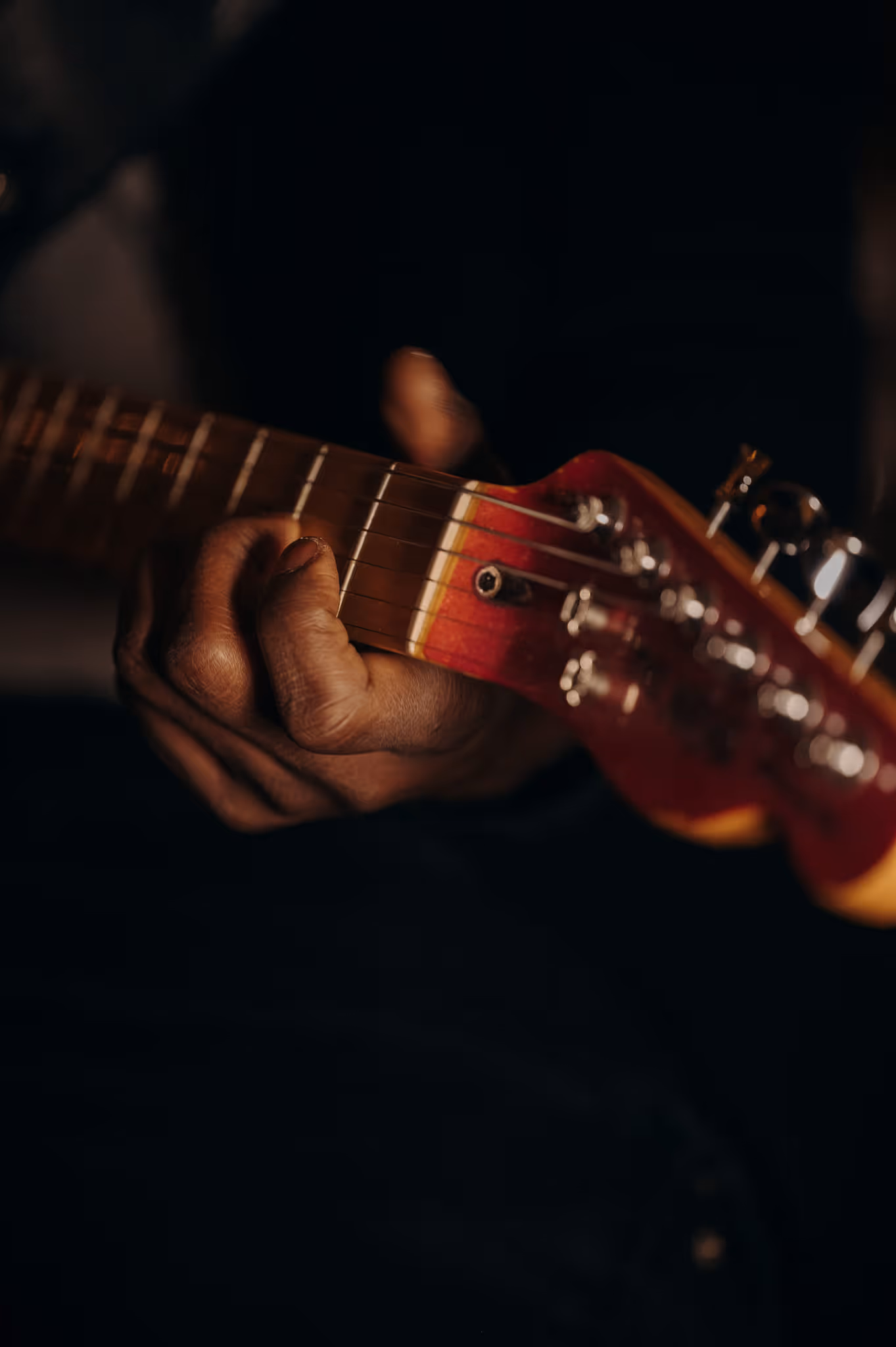 Close-up of a hand playing electric guitar on stage at the ChaCha restaurant, from the band Annie Famose (AFgroup).