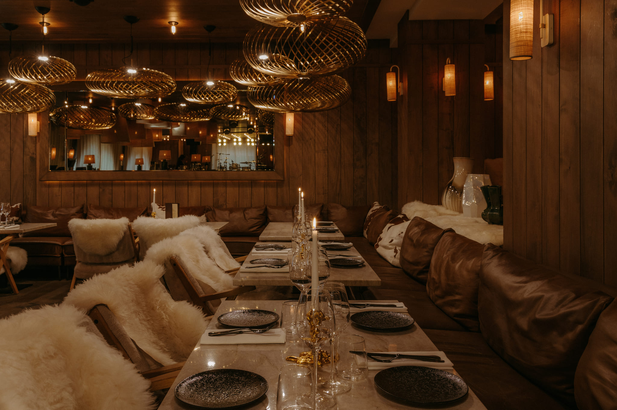 Elegant dining room at ChaCha in Megève, part of the Annie Famose group (AFGroupe), featuring linen-draped tables and plush fur seating.