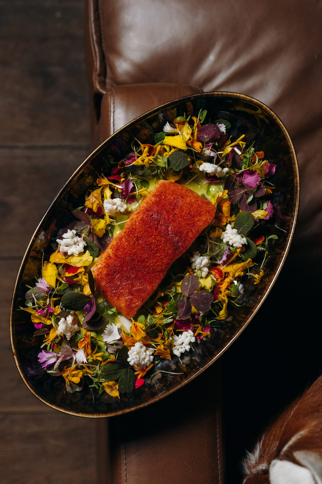 Perfectly cooked fish fillet on a bed of colorful garnish at ChaCha restaurant in Megève, Annie Famose group (AFGroupe).