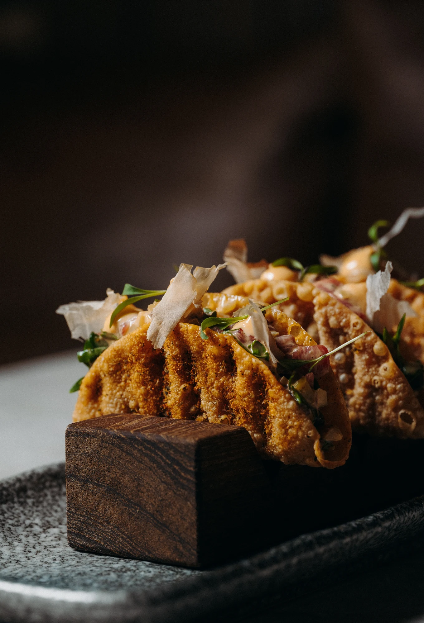 Hot and crispy signature dish served on a wooden block at the ChaCha restaurant in Megève, Annie Famose Group (AFGroupe).