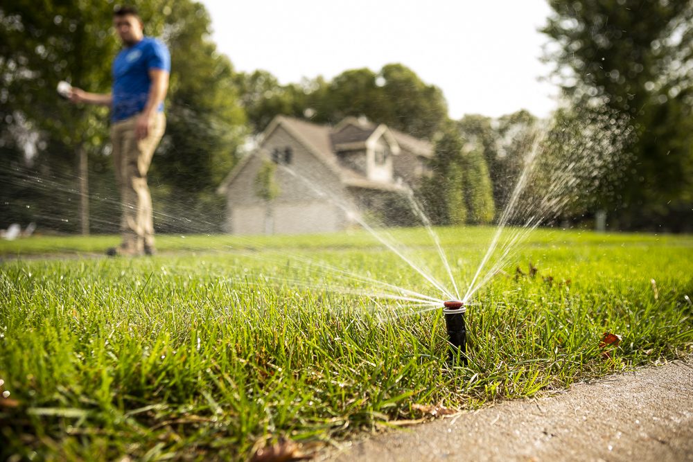 irrigation technician tests sprinkler heads