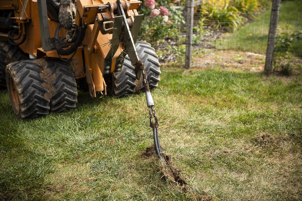 a lawn trenching machine excavating for a lawn sprinkler installation