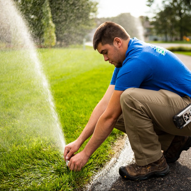 irrigation technician testing a lawn sprinkler head
