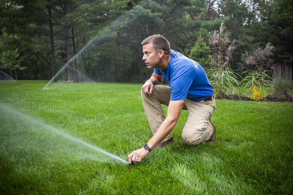 irrigation team adjusts sprinkler heads