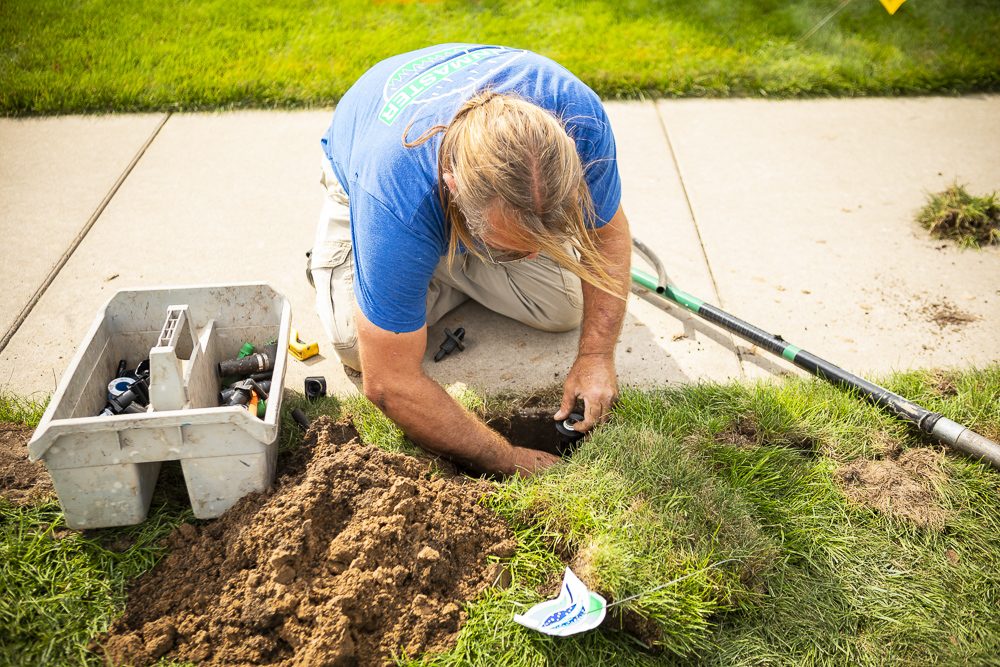irrigation expert repairs sprinkler system