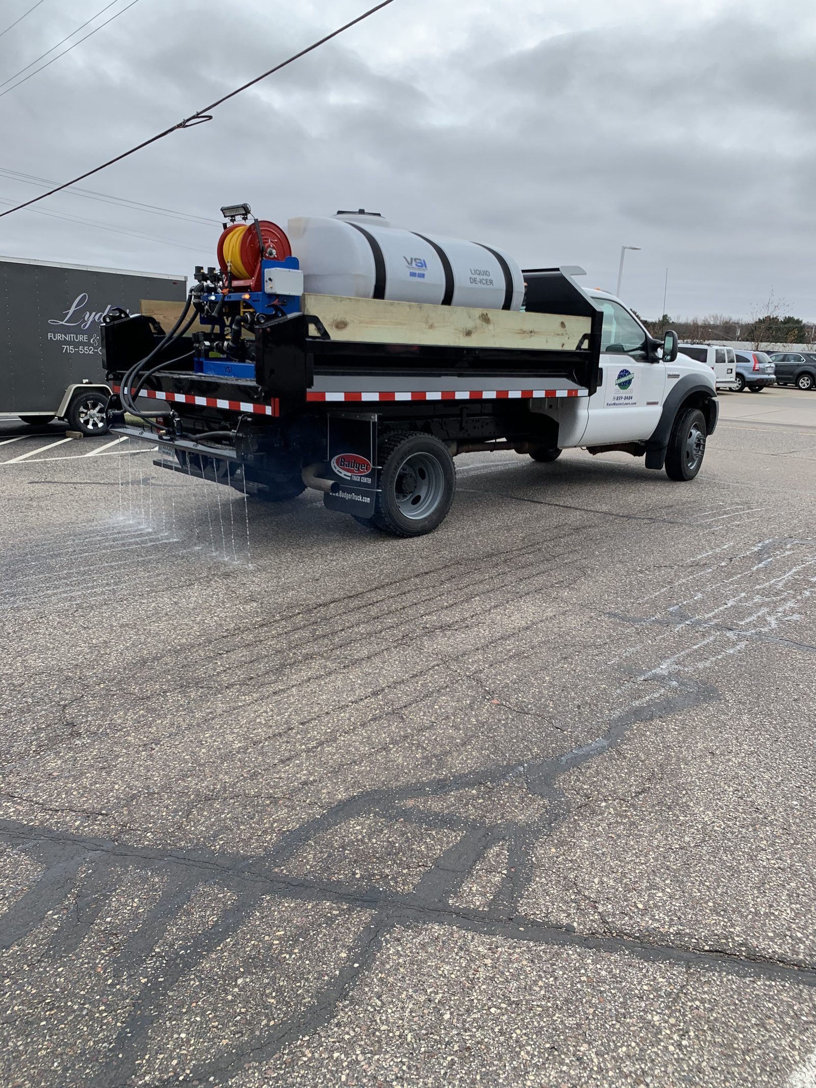 commercial snow removal truck pre-treating a parking lot with salt brine